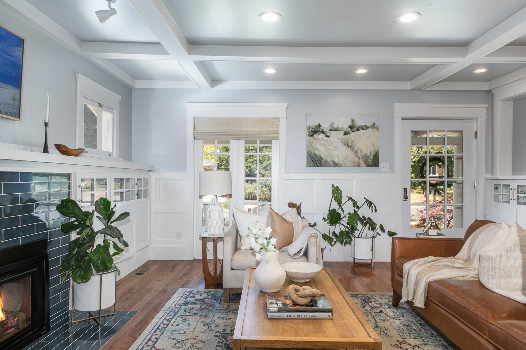 Living area featuring wood-finish flooring, white coffered ceilings with recessed lighting, and a fireplace with blue subway tile surround