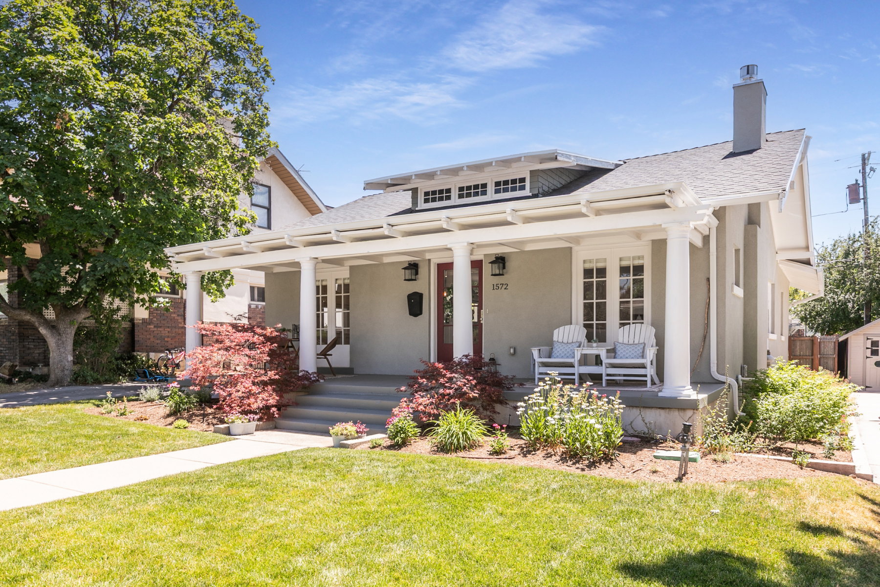 Stucco exterior with a covered porch featuring white columns