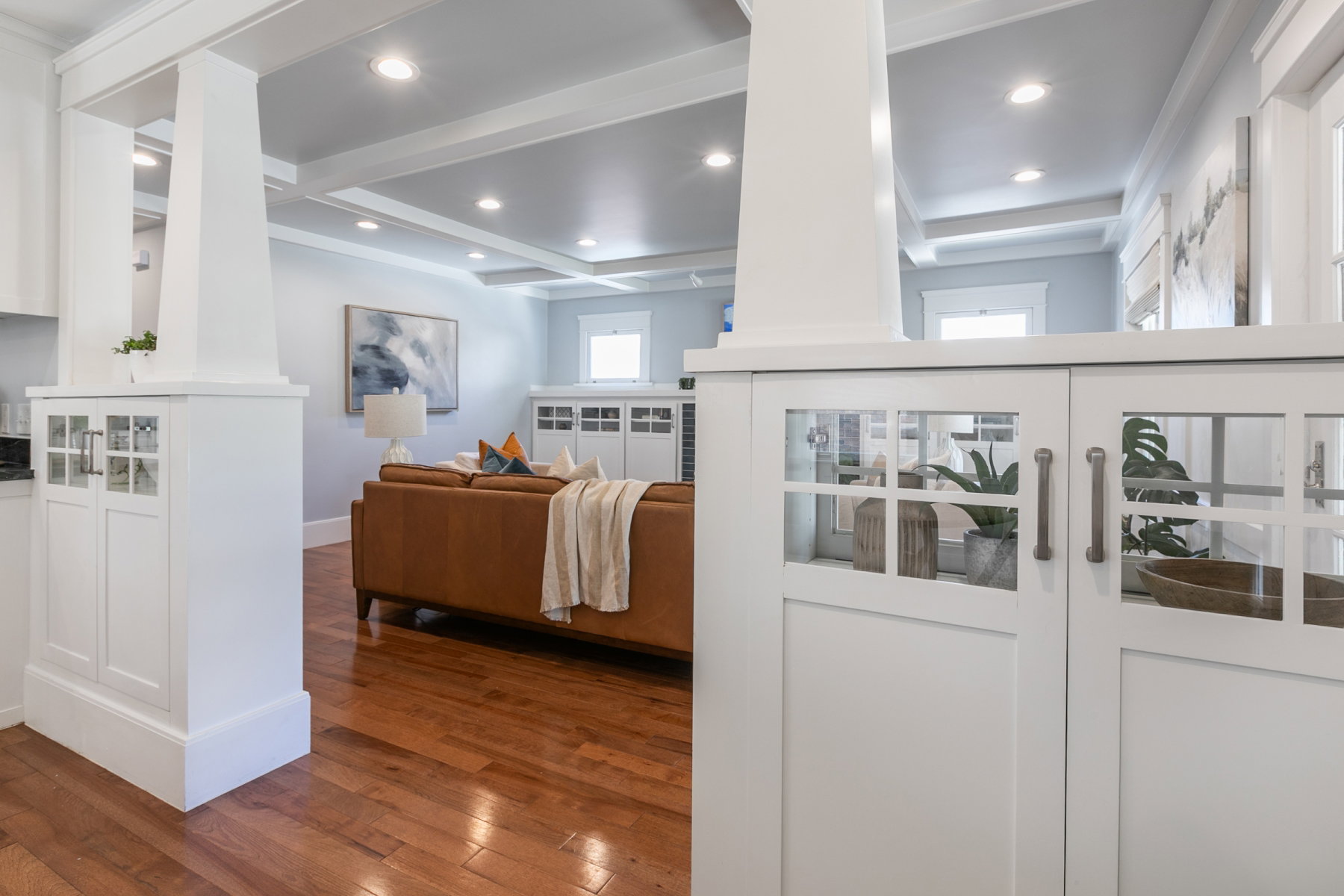 White built-in cabinetry with glass-paneled doors and brushed nickel hardware