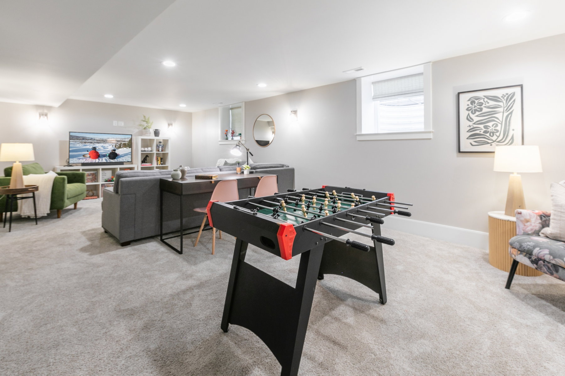 Spacious recreational area featuring light gray wall paint, recessed lighting, and light gray carpeted flooring