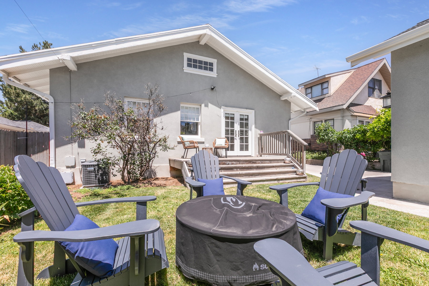 Manicured lawn area with a multi-level wooden deck and French doors