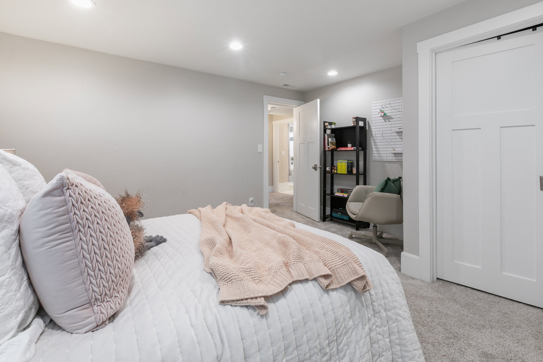 Neutral wall paint, recessed lighting, and light gray carpet create a bright interior