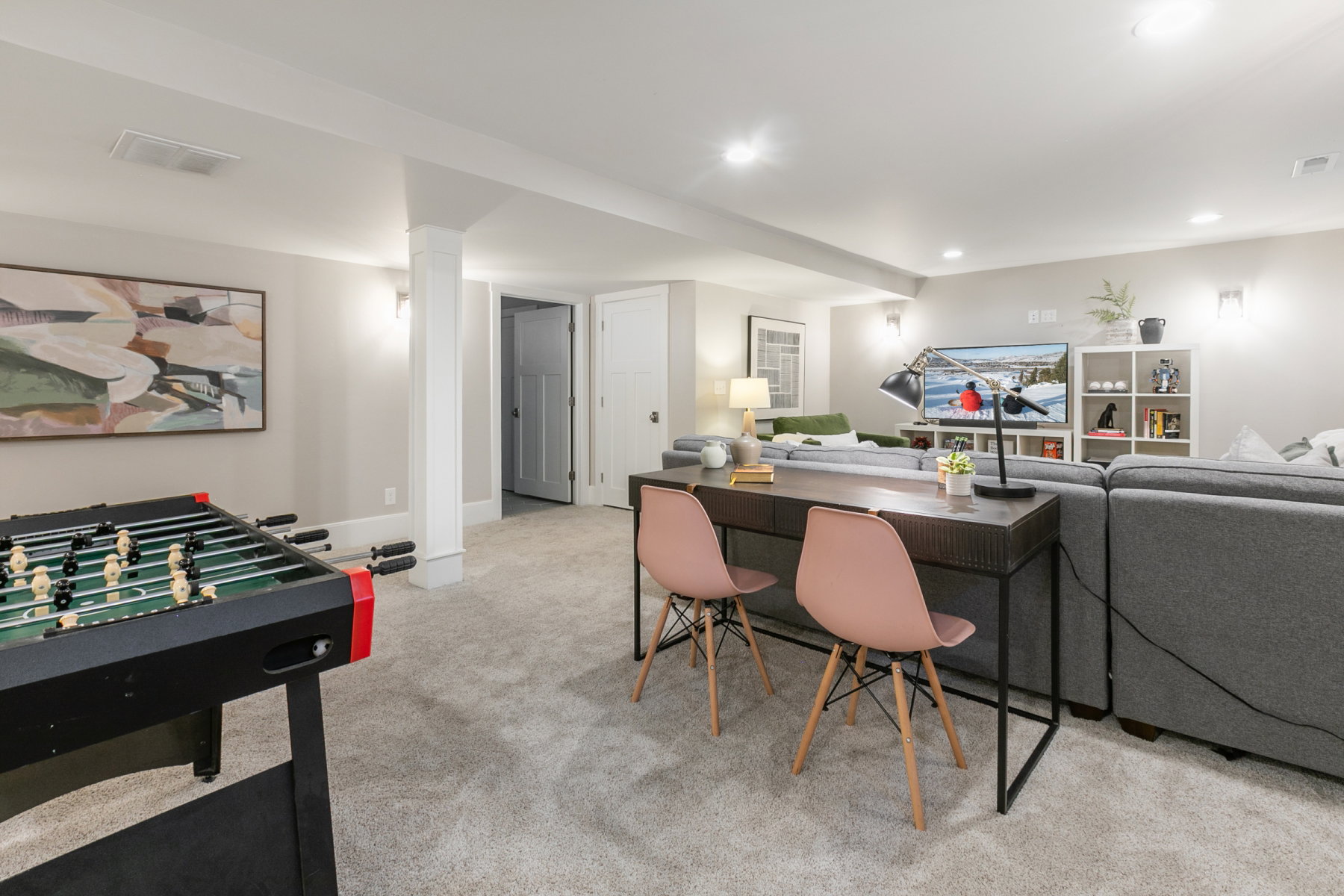 Finished lower level featuring neutral carpeting, recessed lighting, and support columns