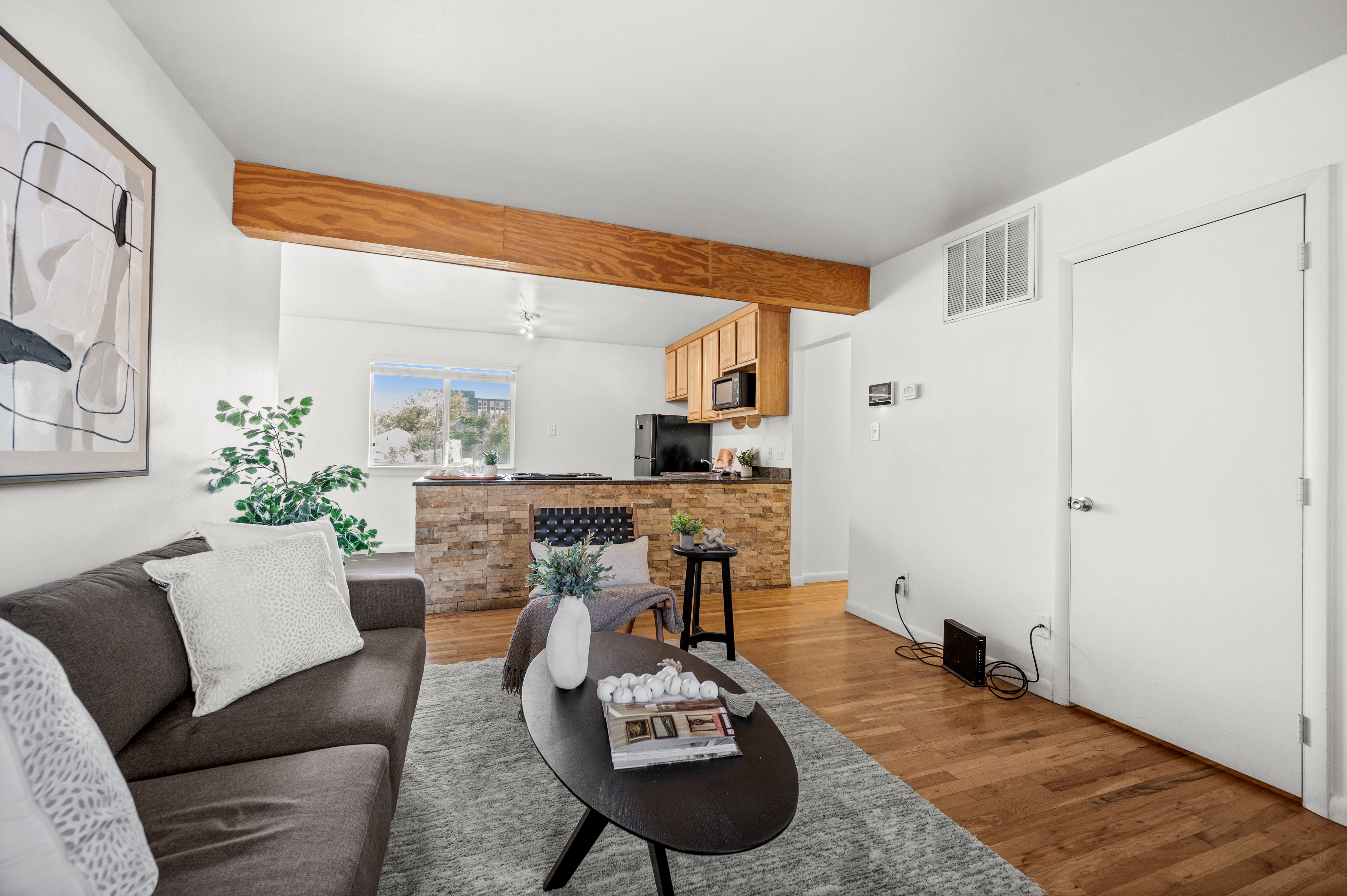 Living room with hardwood-finish flooring and a decorative exposed beam