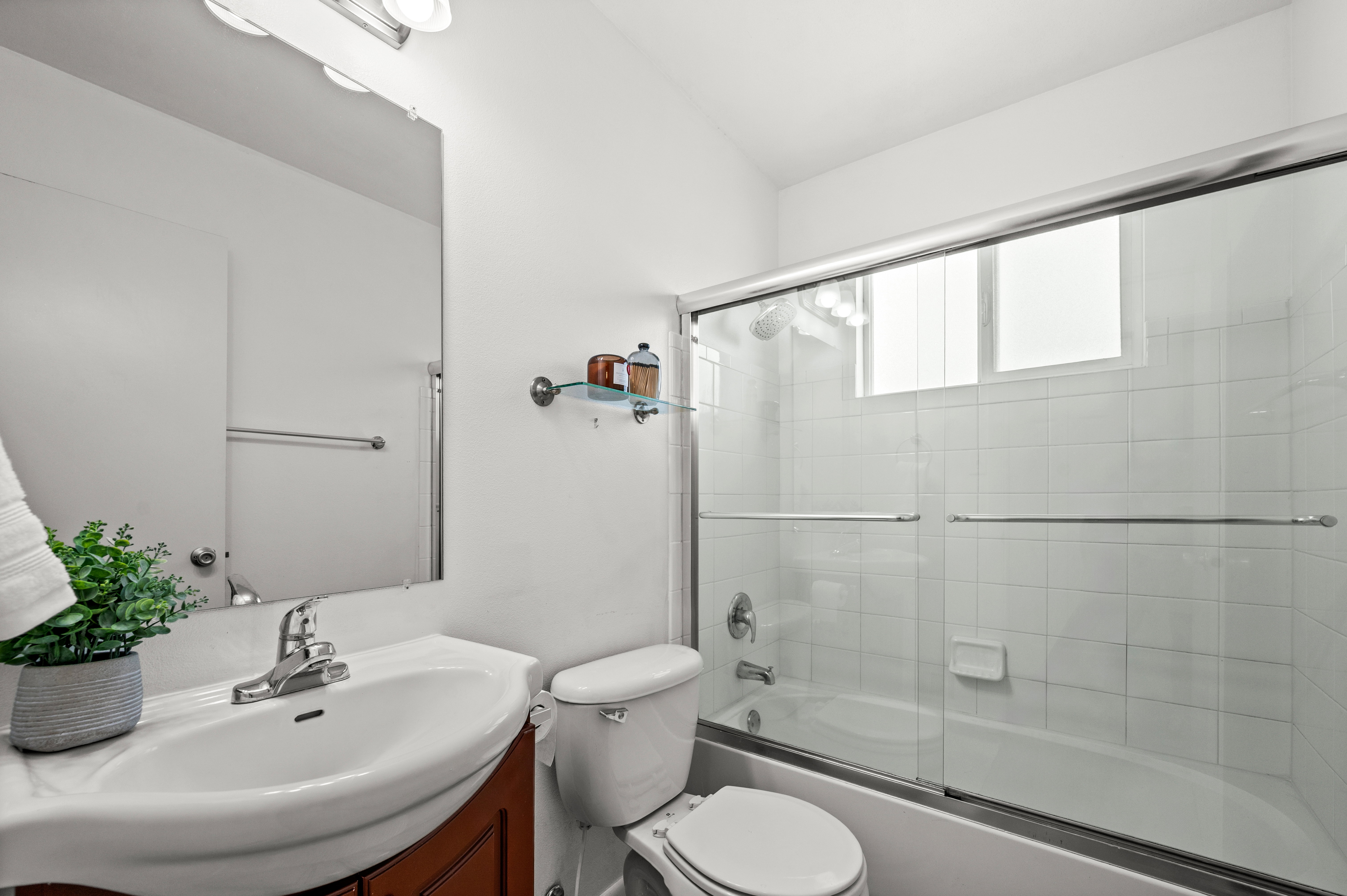 Bathroom featuring a white vanity with an integrated sink, a rectangular mirror, and an overhead vanity light
