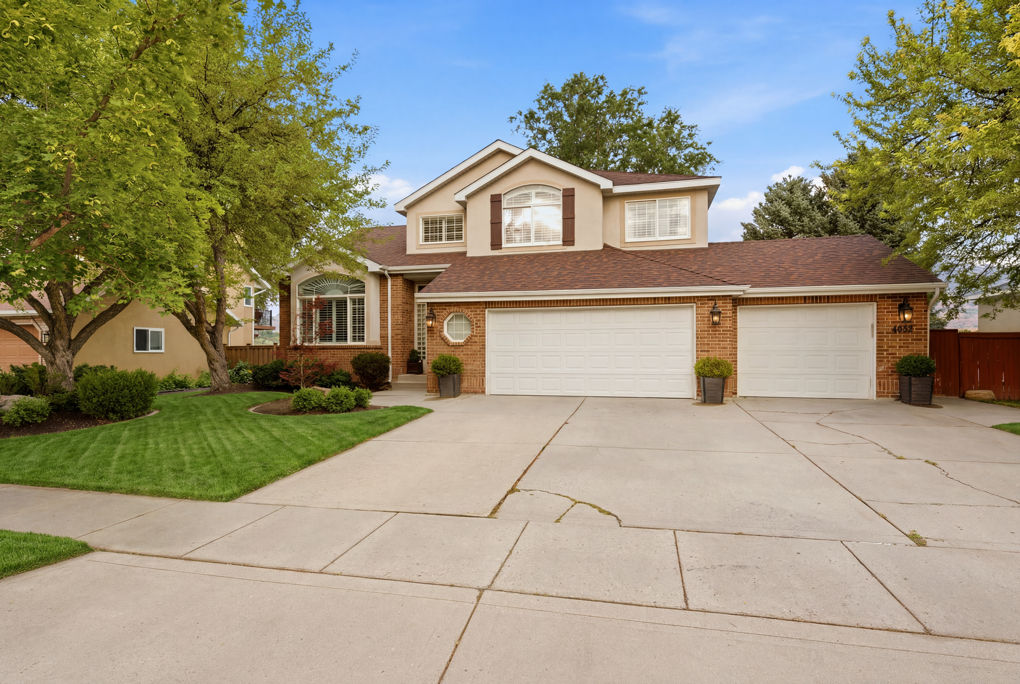 Brick and stucco exterior with multiple gables and a multi-car driveway