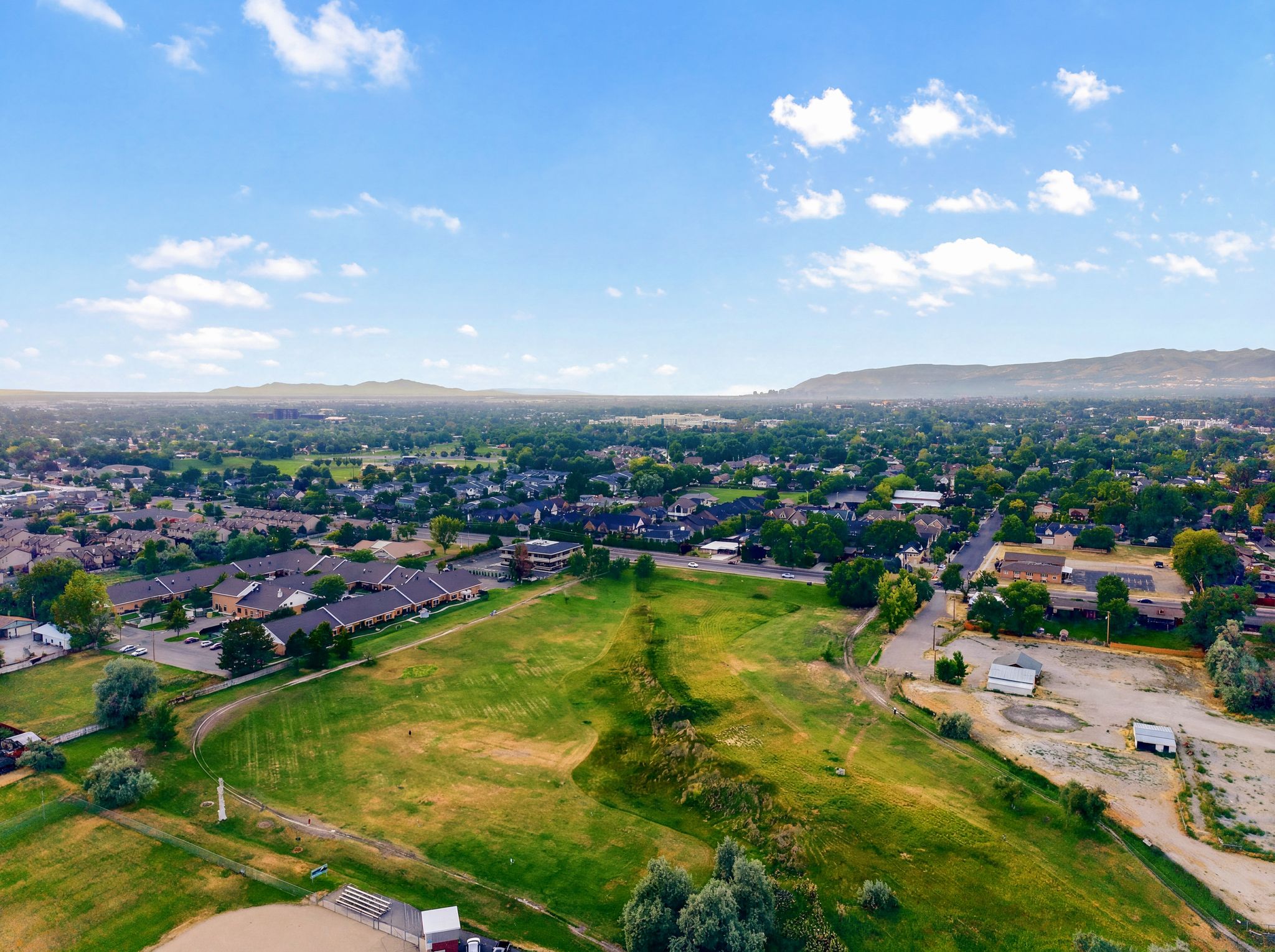 Expansive aerial perspective showcasing a verdant landscape with rolling hills and distant mountains