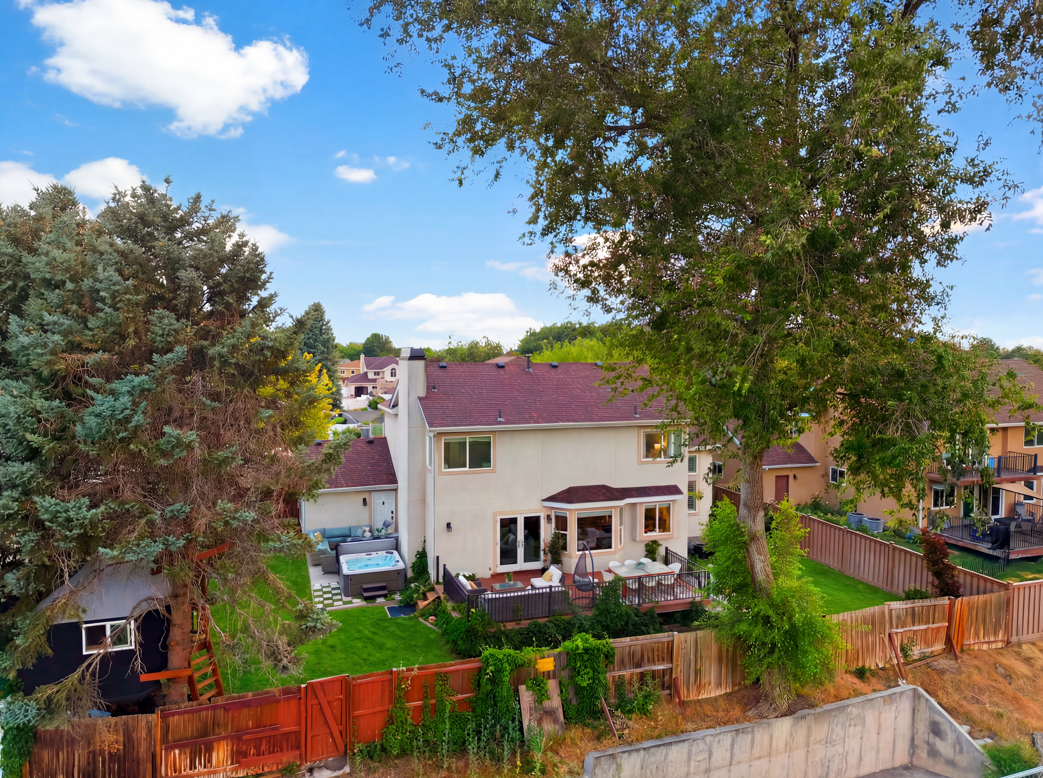 Rear exterior featuring a multi-level deck, built-in spa, and a lower-level grass area