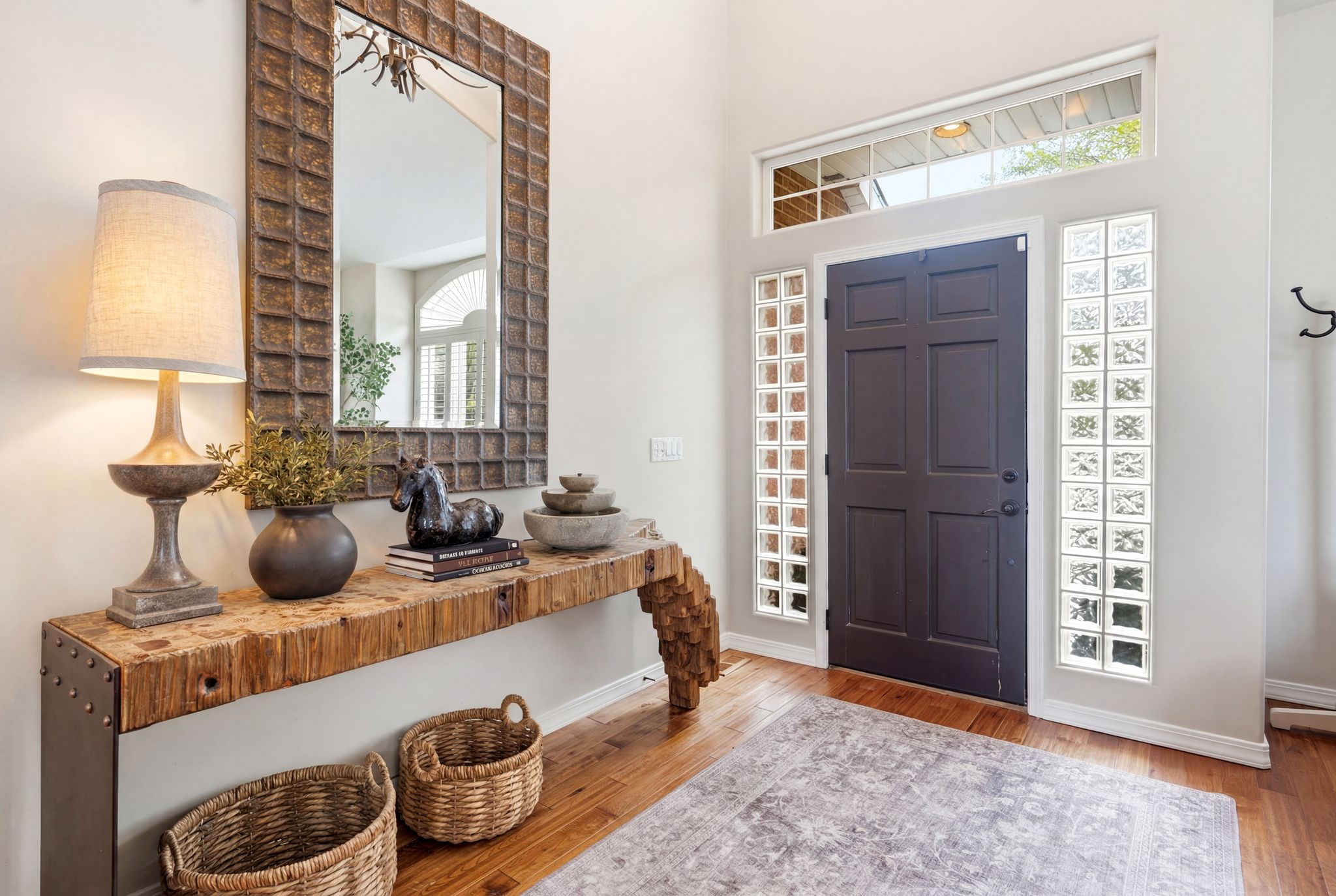 Entryway featuring a dark paneled door, vertical glass block sidelights, and a transom window