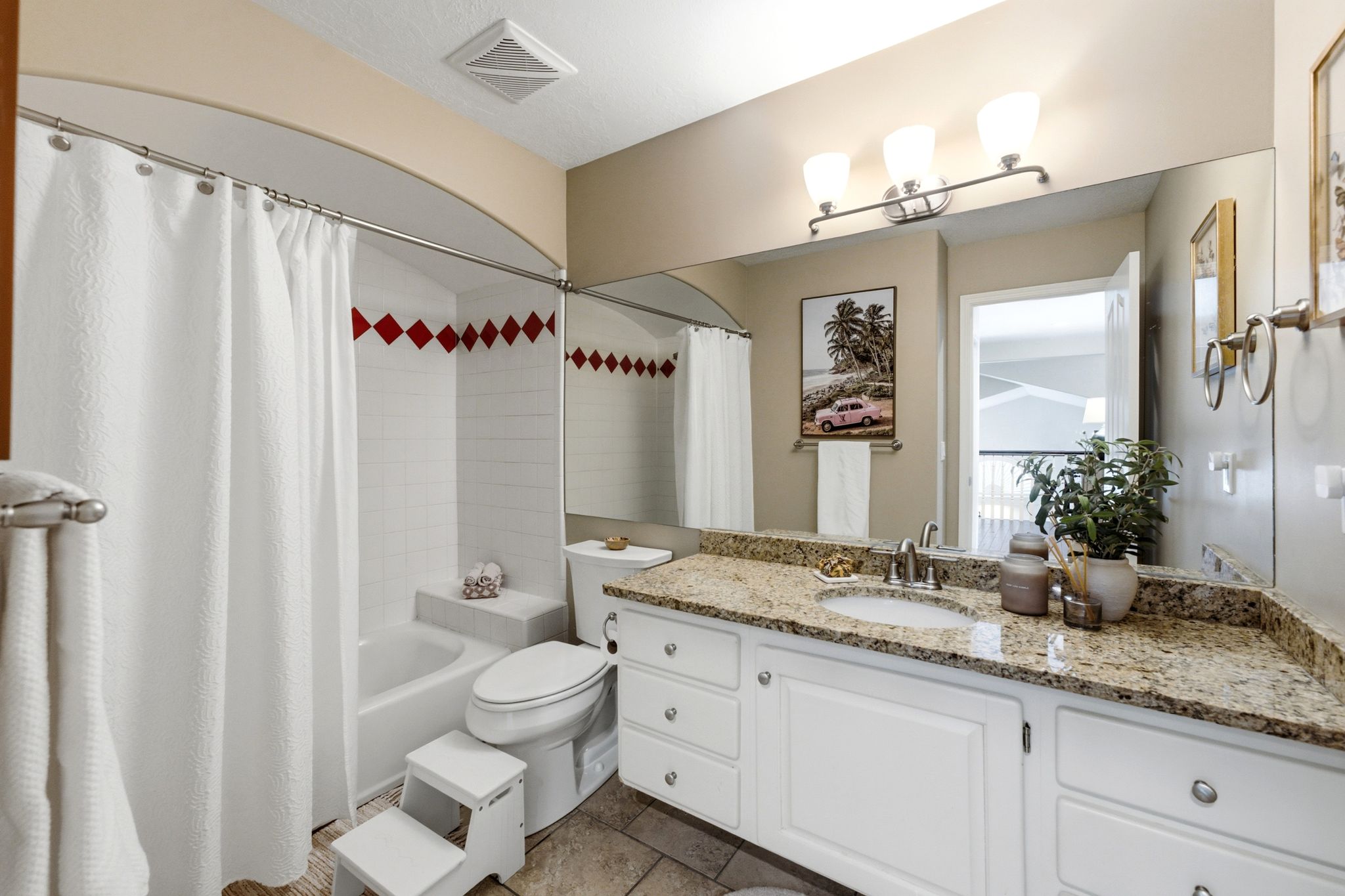 Bathroom featuring a single vanity with a granite countertop, undermount sink, and chrome fixtures
