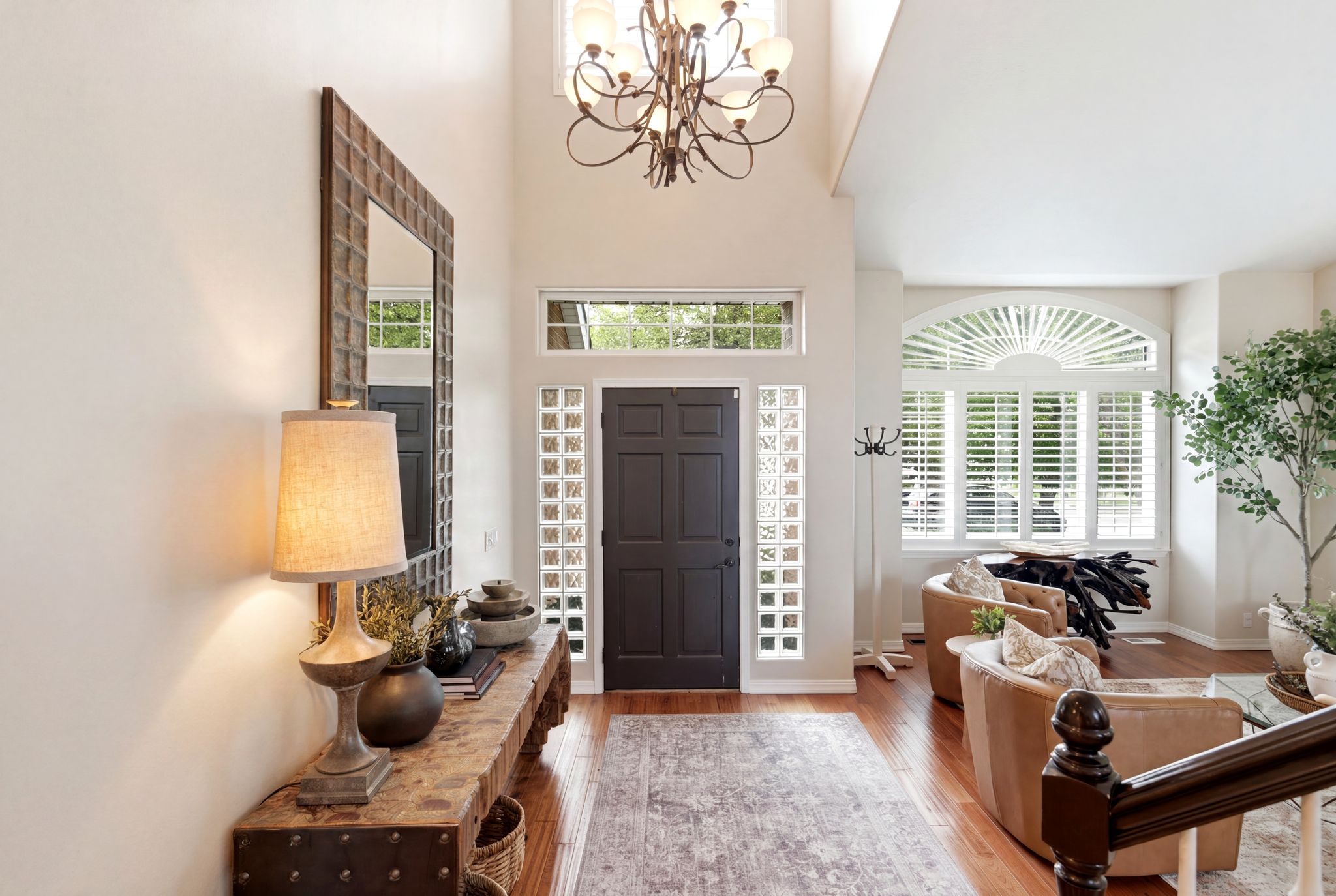 Two-story entryway featuring a dark-paneled door, glass block sidelights, and a transom window