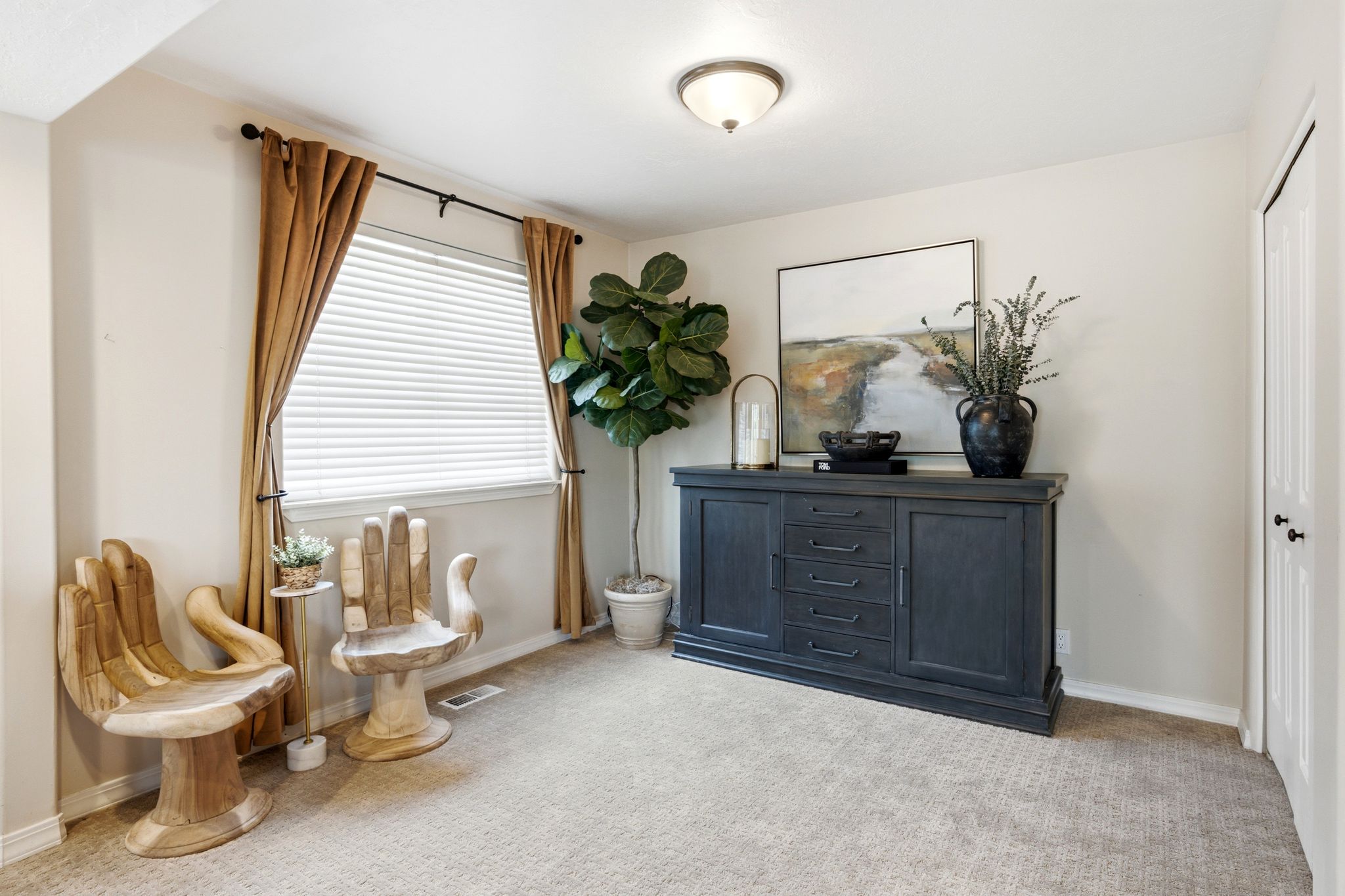 Carpeted room with a window featuring blinds and drapes, a built-in dark wood console with storage, and a ceiling-mounted light fixture