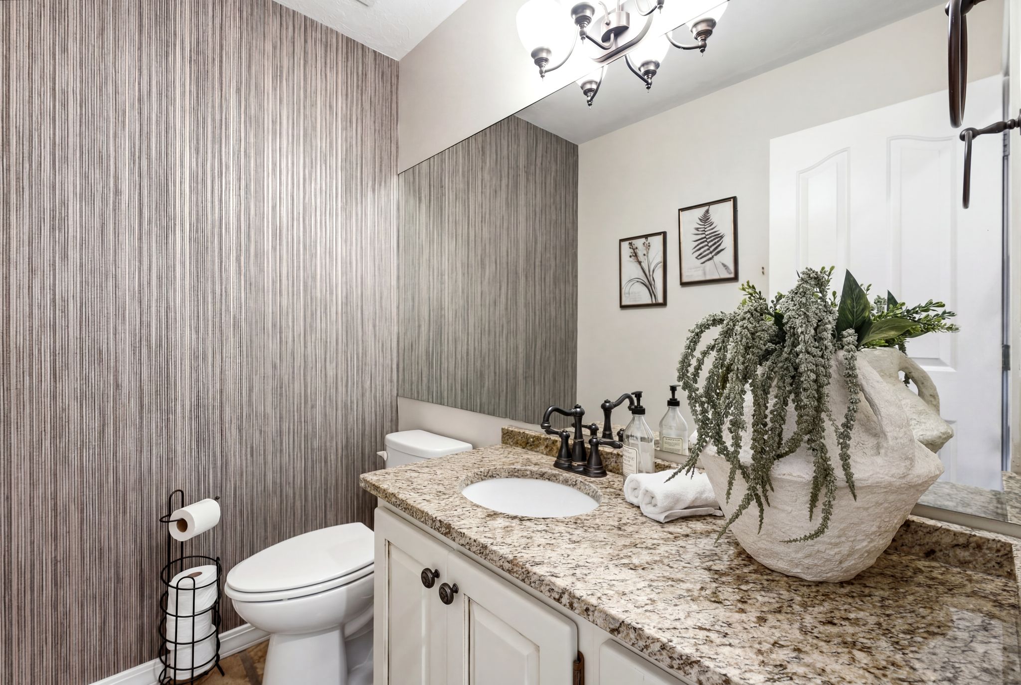 Bathroom vanity featuring a light granite countertop with an integrated sink and dark bronze faucet