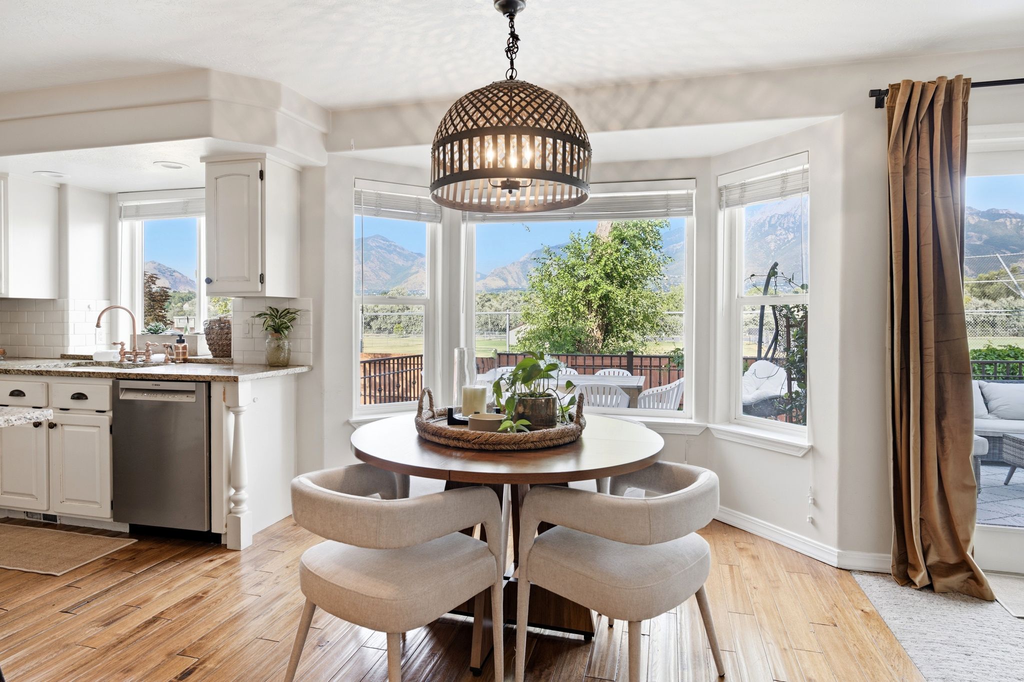 Dining area featuring a bay window, wood-finish flooring, and a decorative pendant light