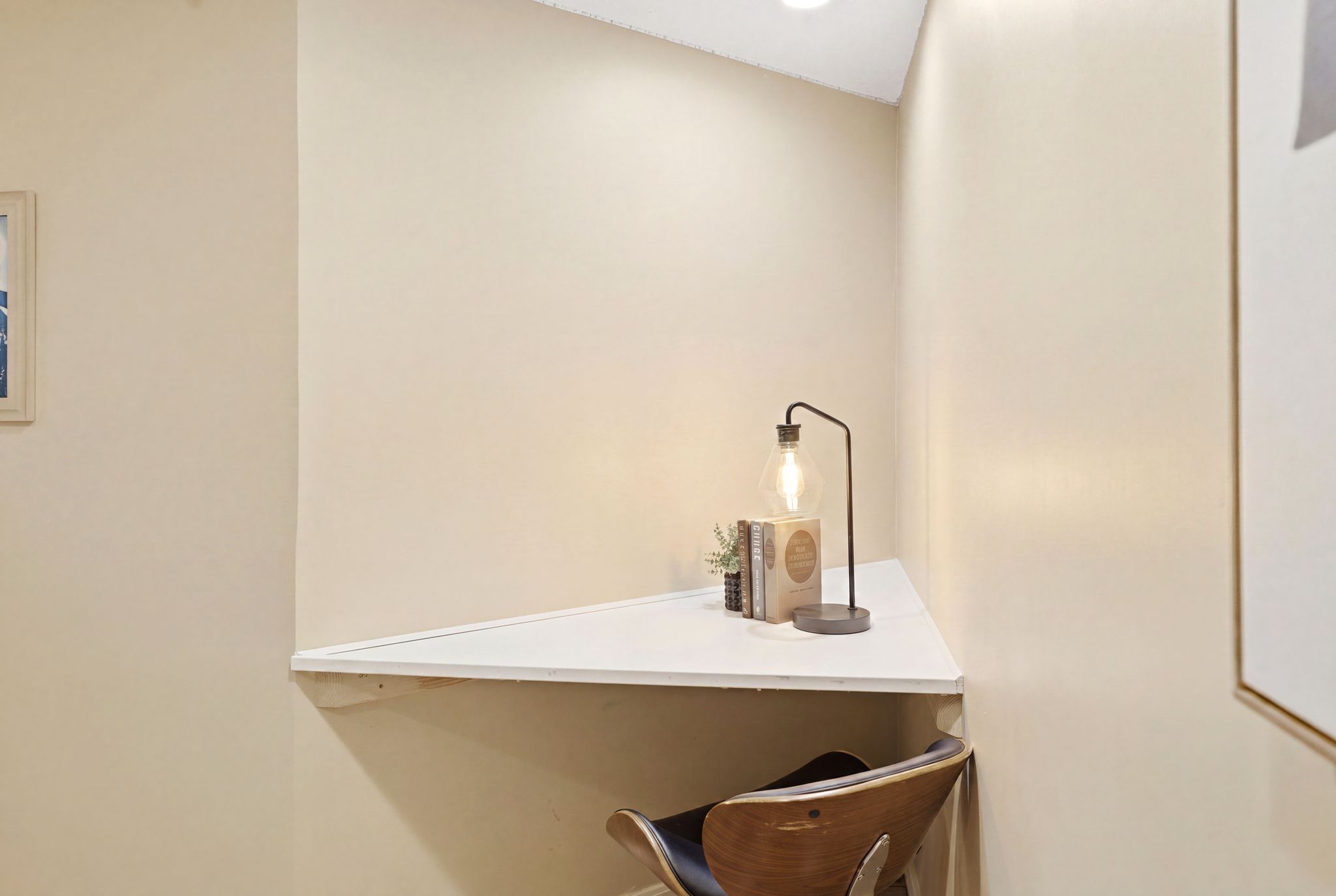 Built-in corner desk with a white surface, providing a dedicated workspace within the room