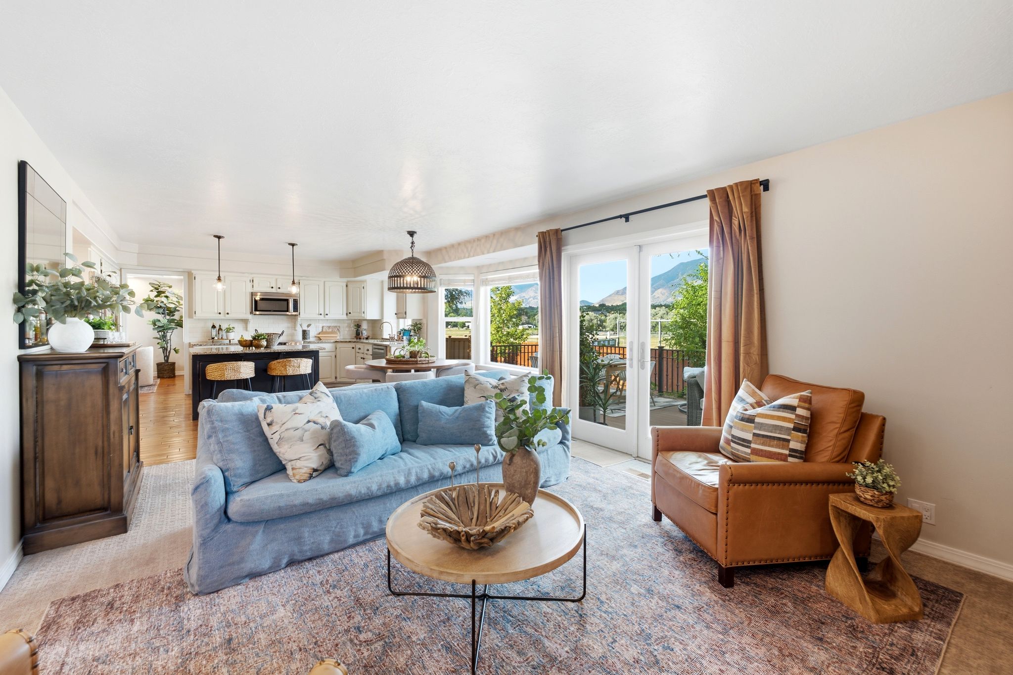 Open-concept living area with light-toned walls and carpeted flooring