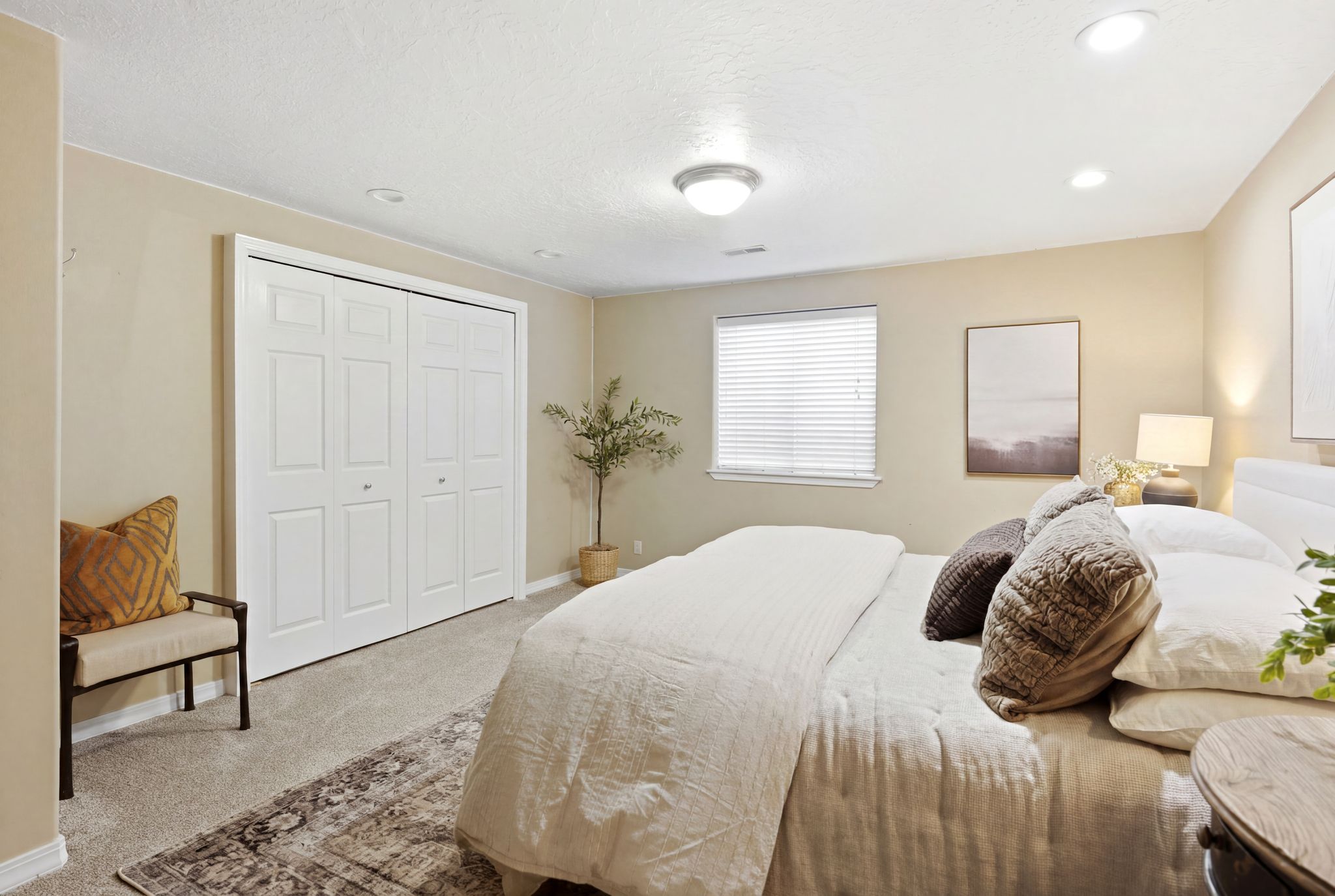 Bedroom with neutral wall color and light-colored carpeting