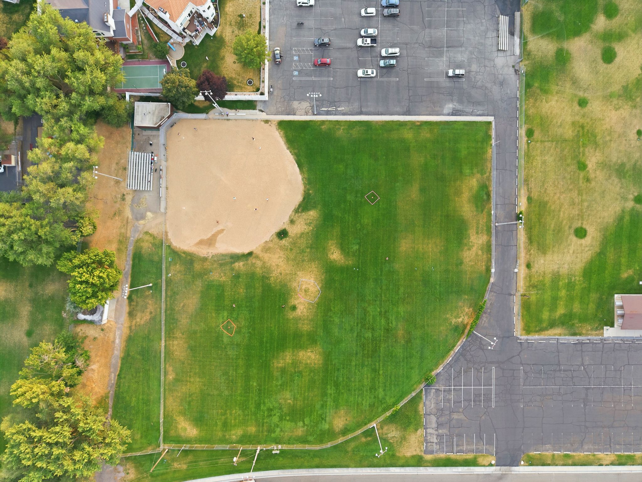 Aerial perspective showcasing expansive green fields and a baseball diamond