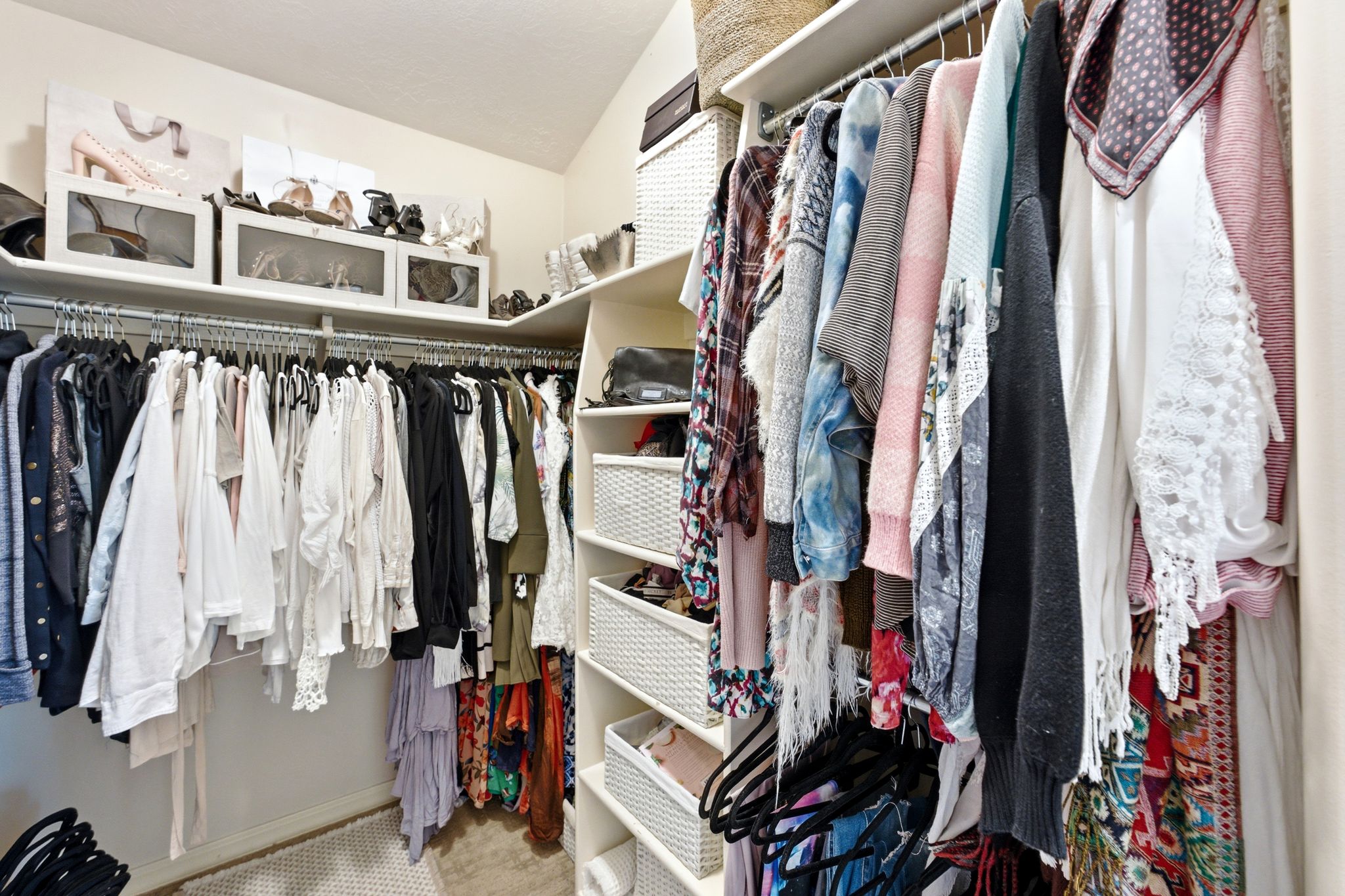 Custom closet system featuring multiple hanging rods, integrated shelving, and dedicated storage compartments