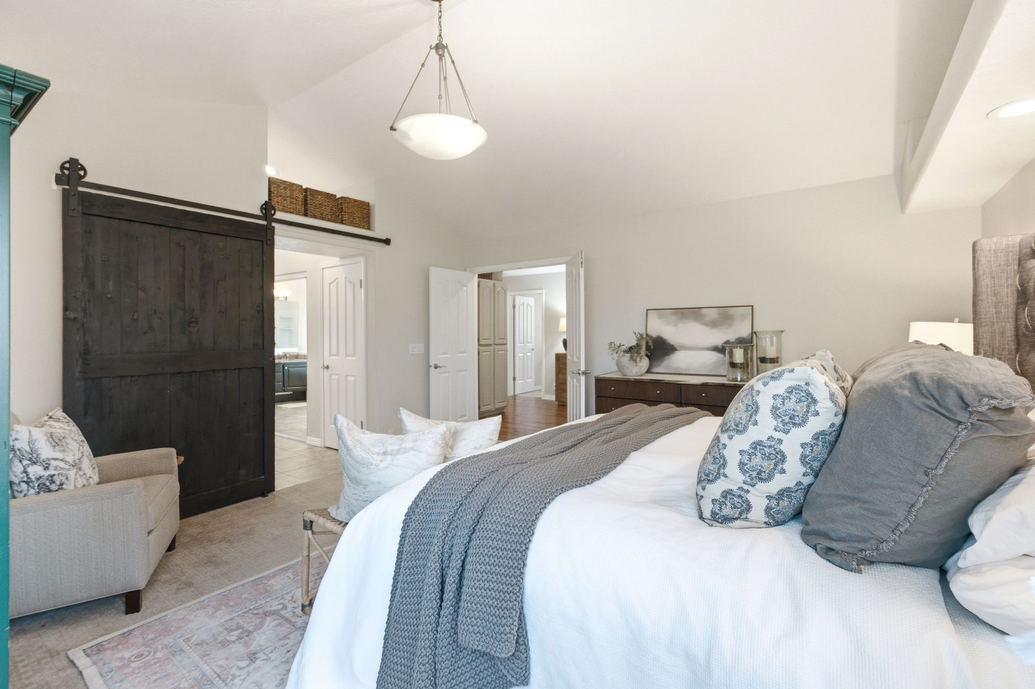 Spacious room featuring a vaulted ceiling and an elegant chandelier