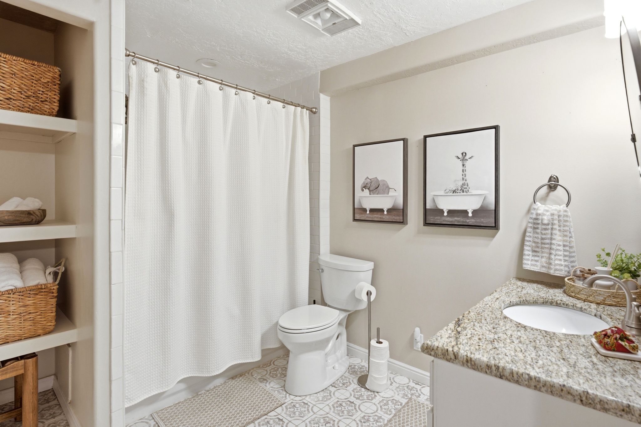 Bathroom featuring a granite countertop vanity with an undermount sink, a white toilet, and built-in shelving