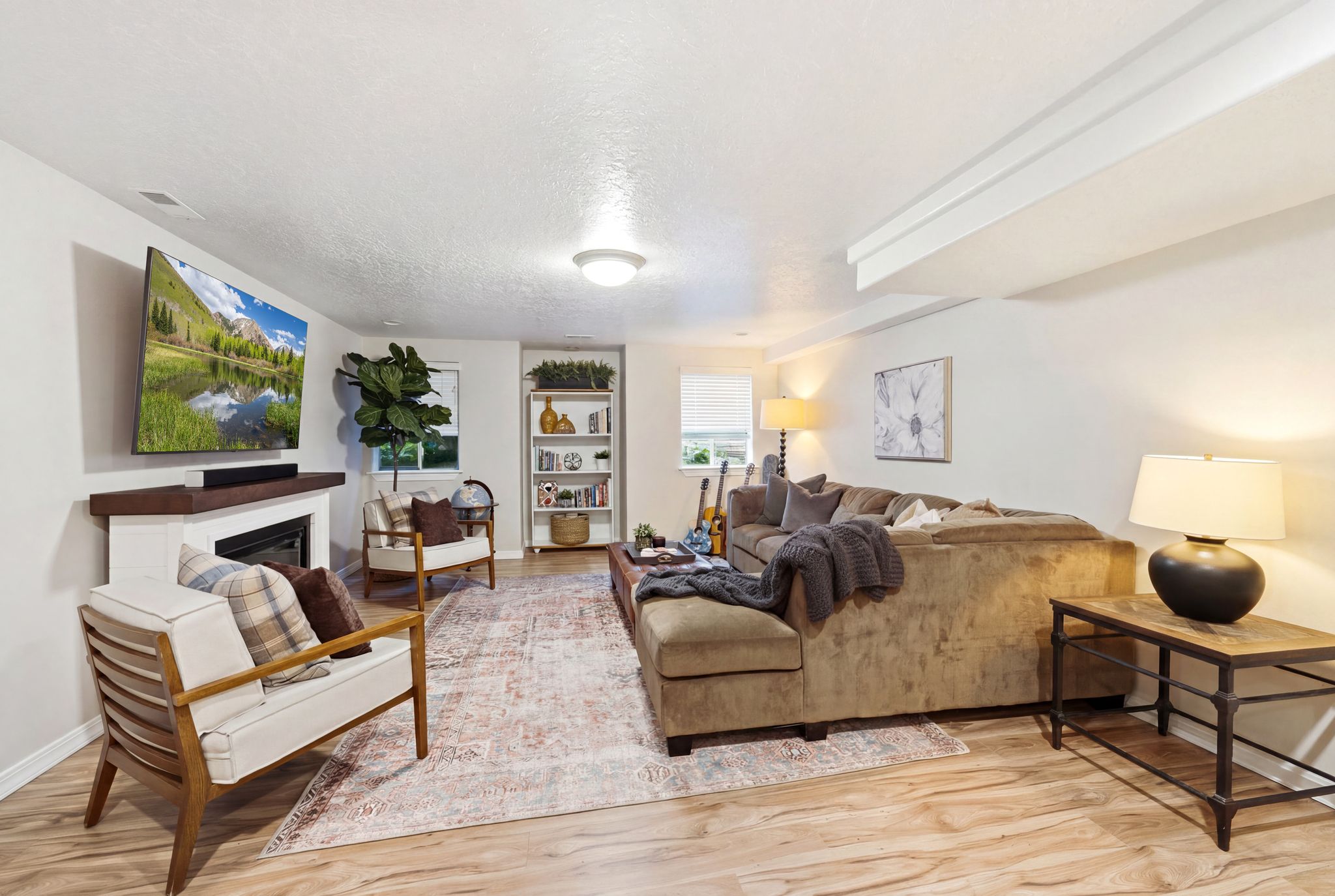 Living area featuring wood-finish flooring, a built-in fireplace with a white mantel and dark wood-tone top, recessed lighting, and a window with blinds