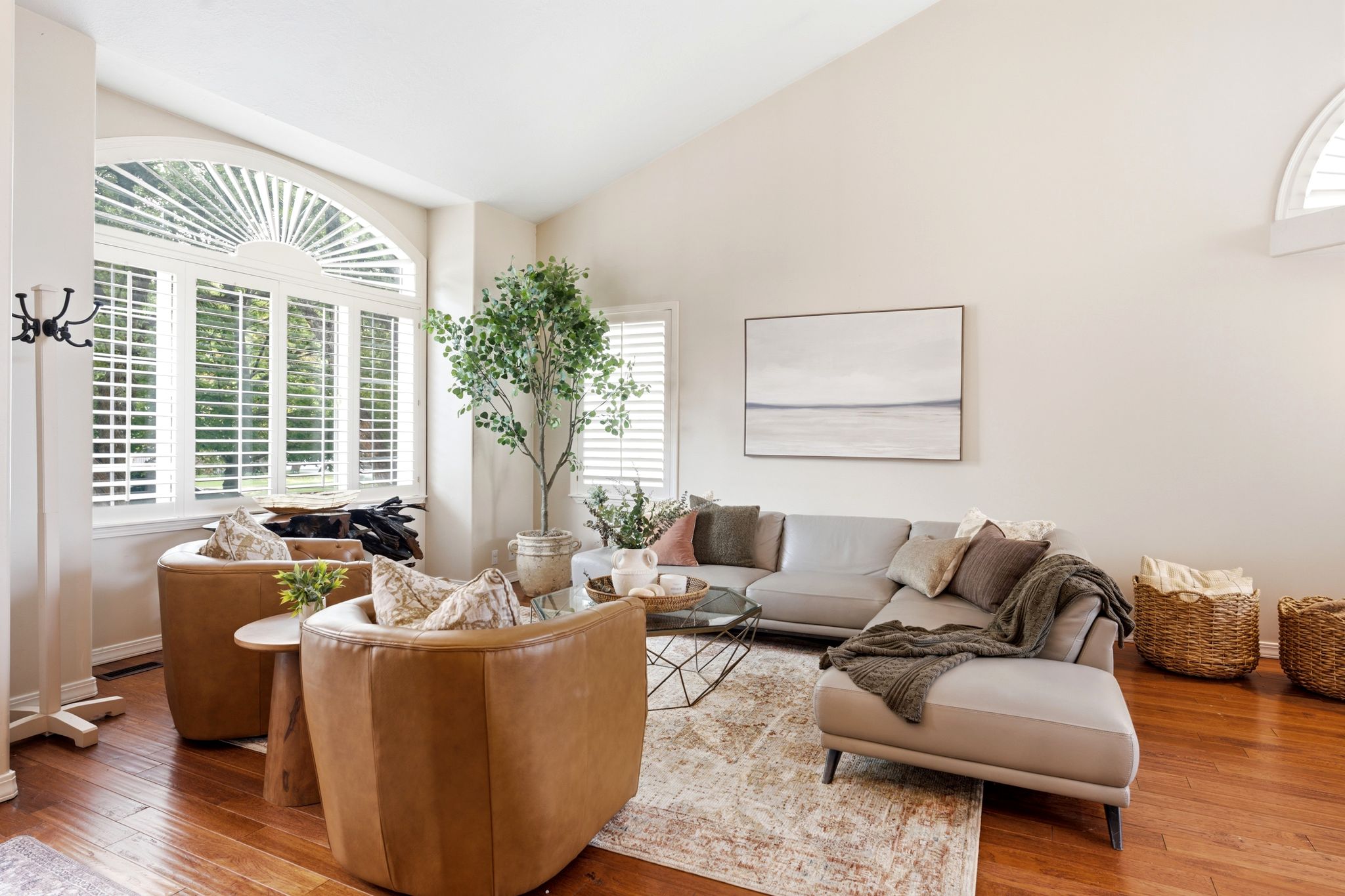 Vaulted ceilings complement the large arched window with plantation shutters