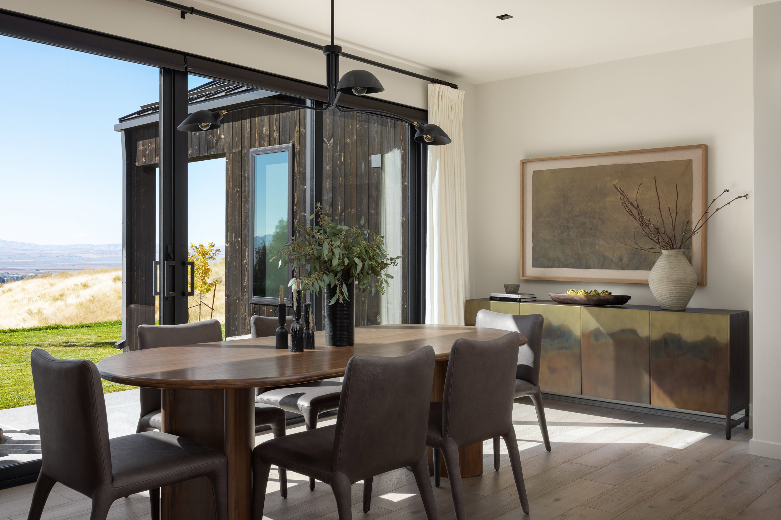 Dining area featuring wide plank wood-finish flooring and a contemporary chandelier