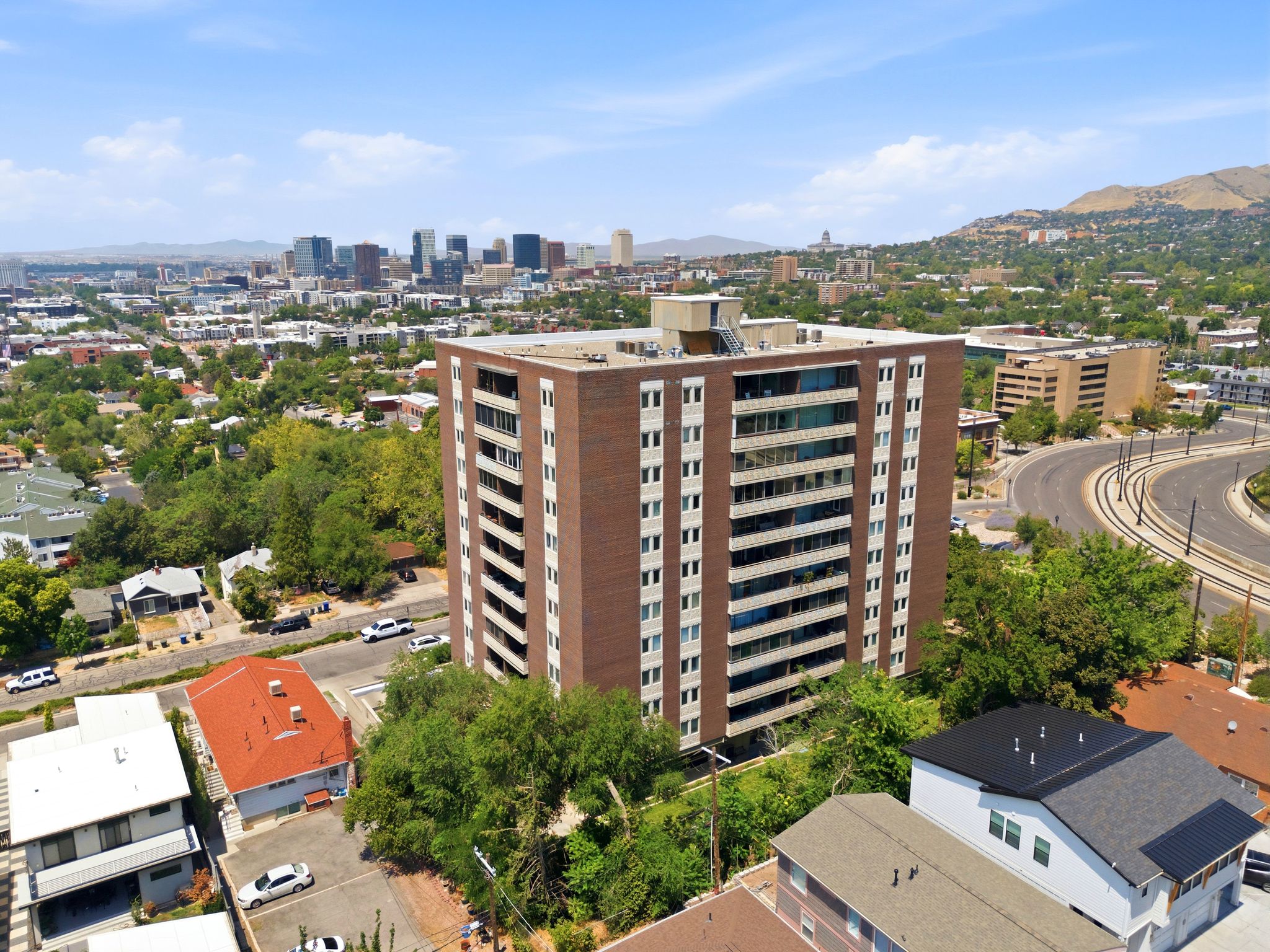 Multi-story building featuring a brick facade with multiple windows and recessed balconies
