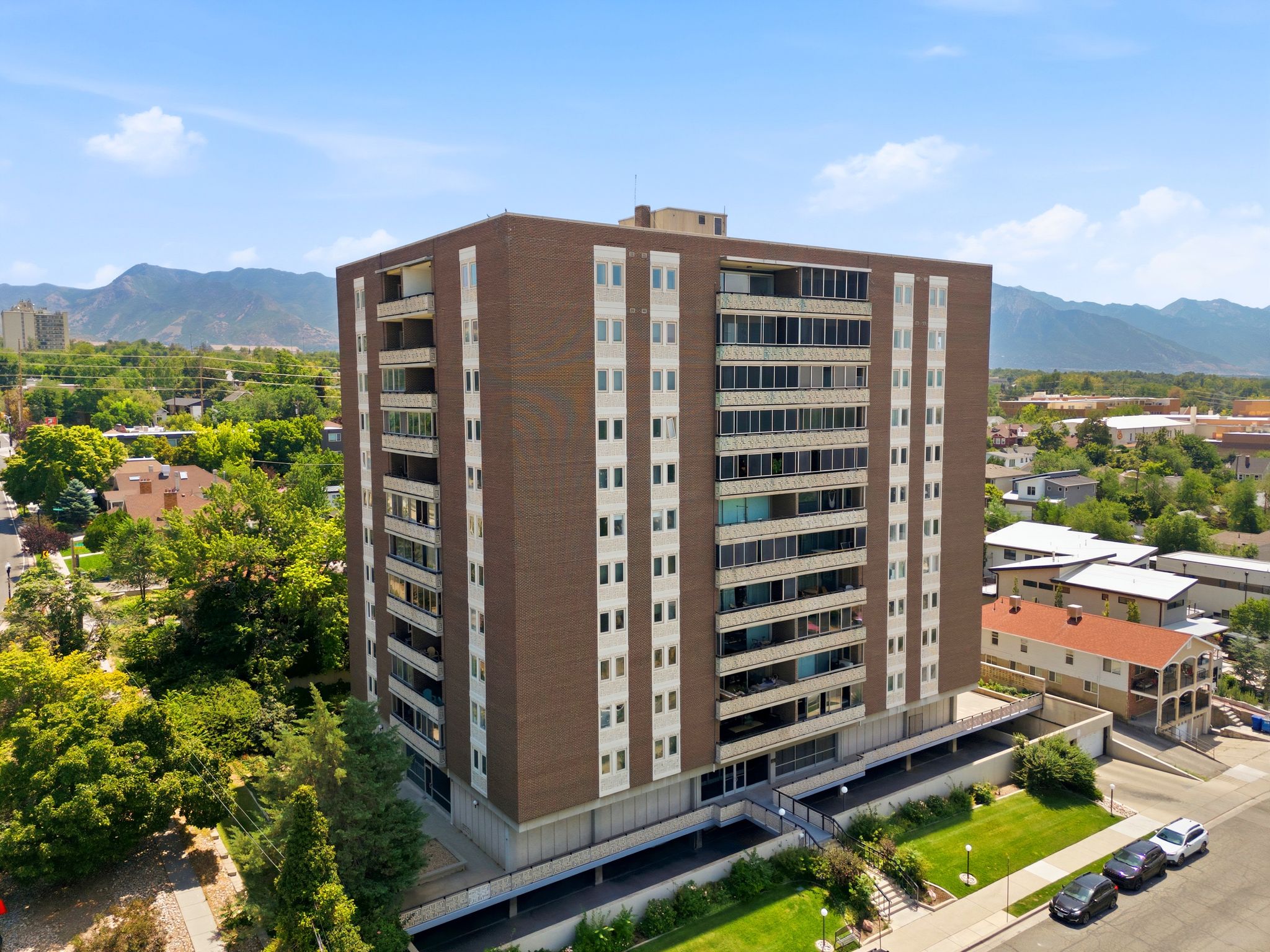 High-rise residential building featuring a brick facade and multiple balconies