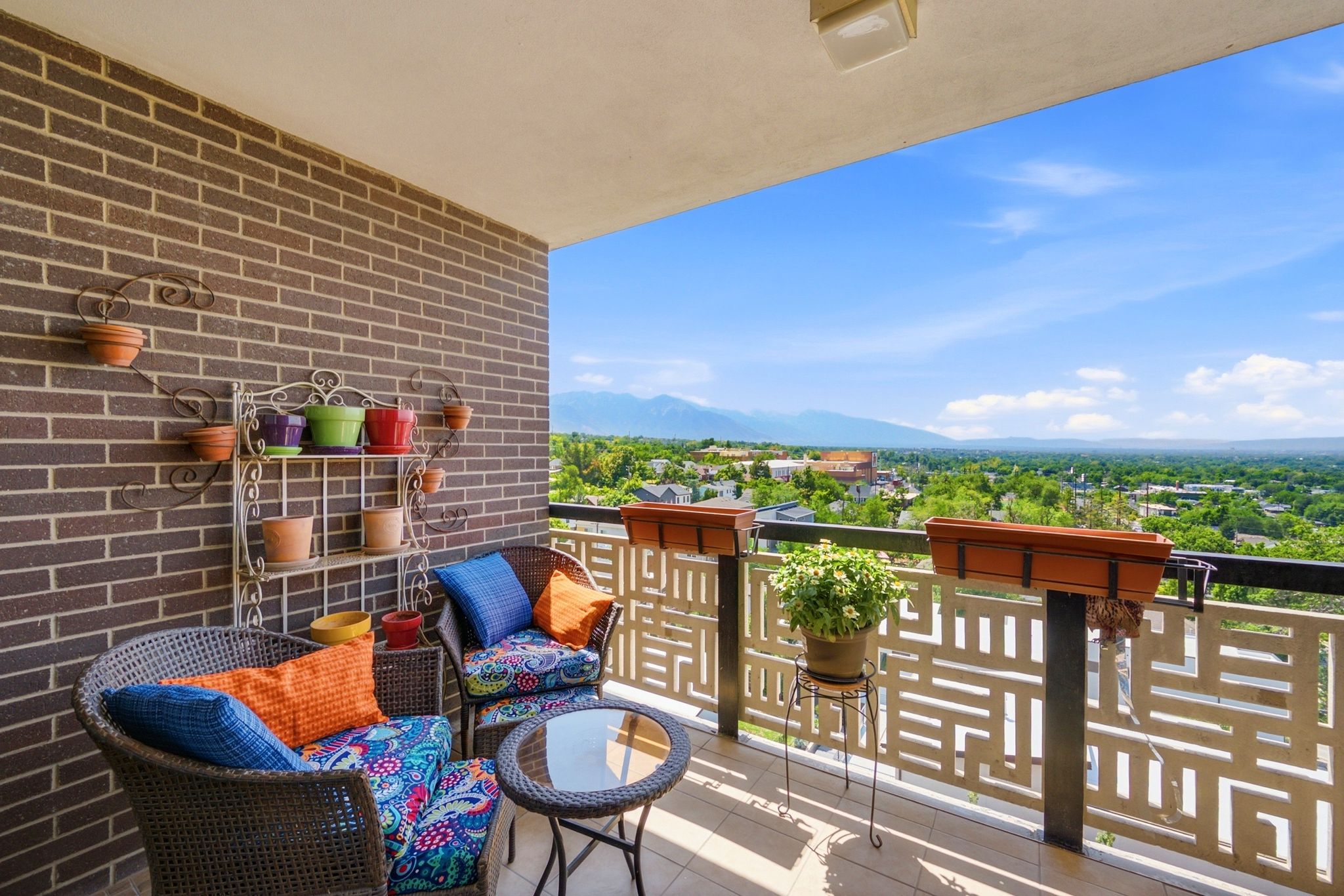 Expansive balcony featuring a brown brick accent wall and light-colored flooring