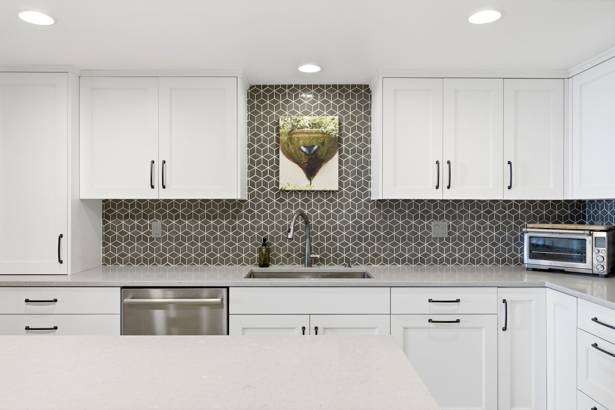 Contemporary kitchen featuring white shaker cabinetry with matte black hardware