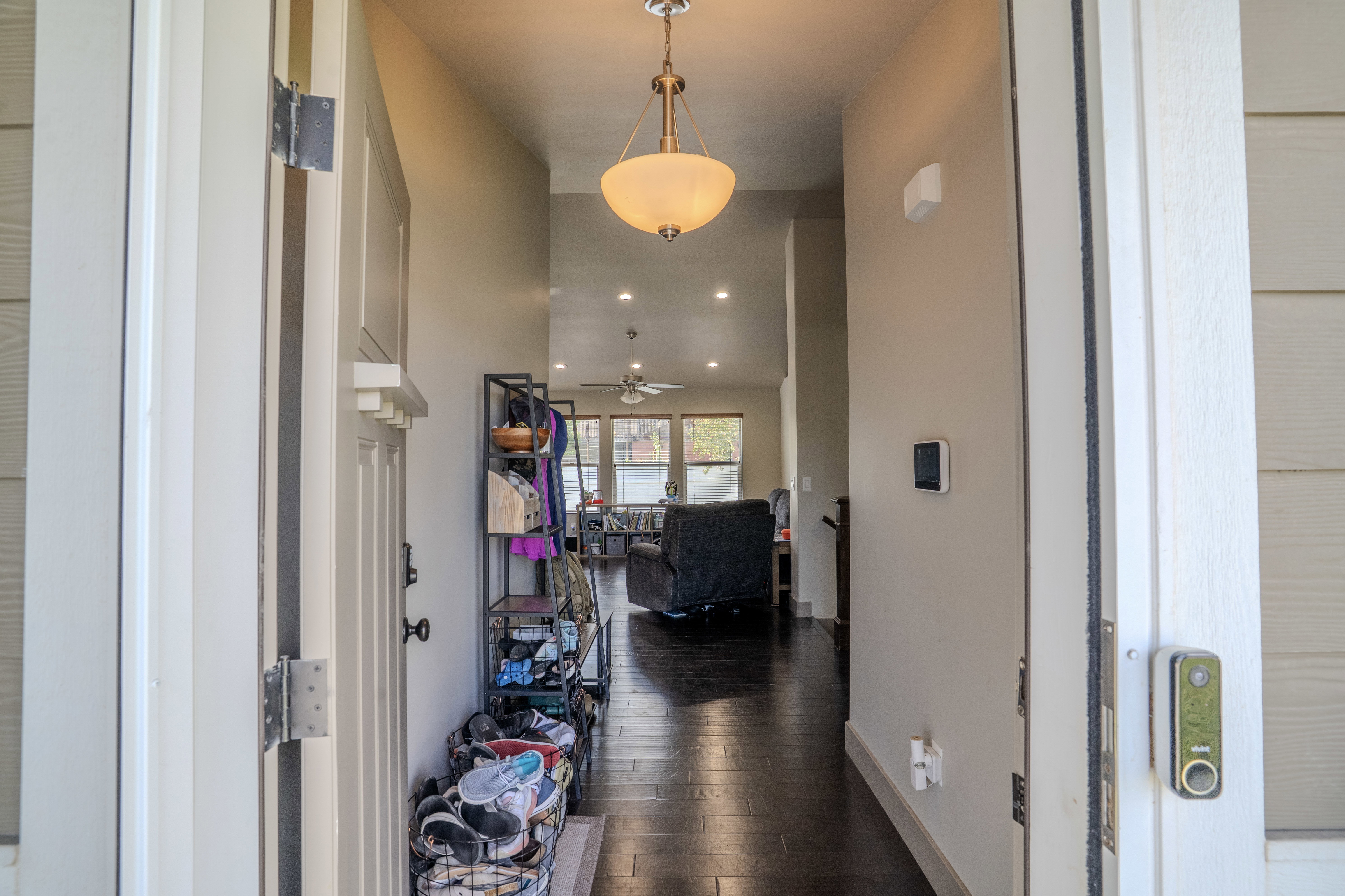 Entryway featuring dark wood-finish flooring and a central pendant light fixture