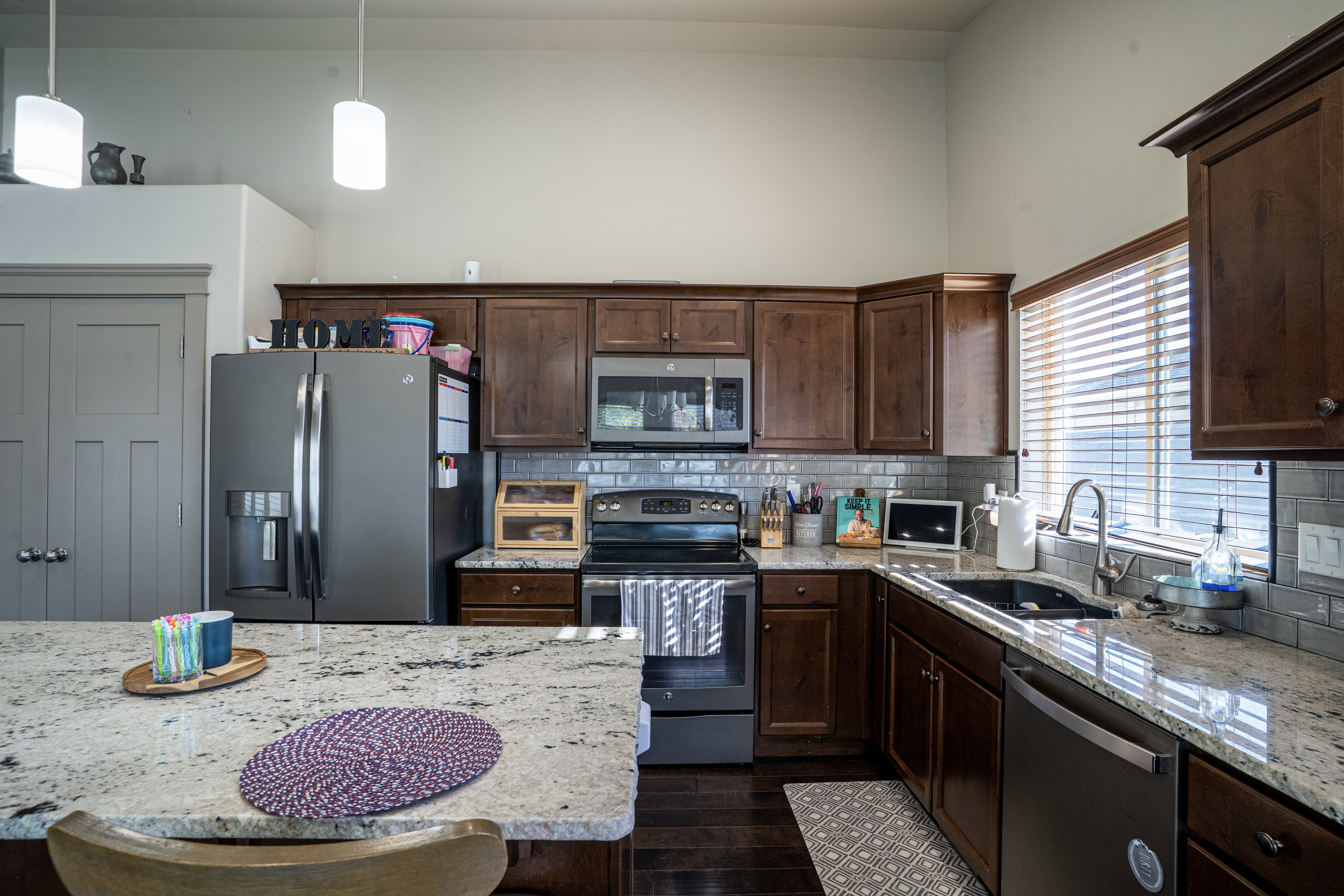 Kitchen featuring dark wood cabinetry, light-toned countertops, and stainless steel appliances