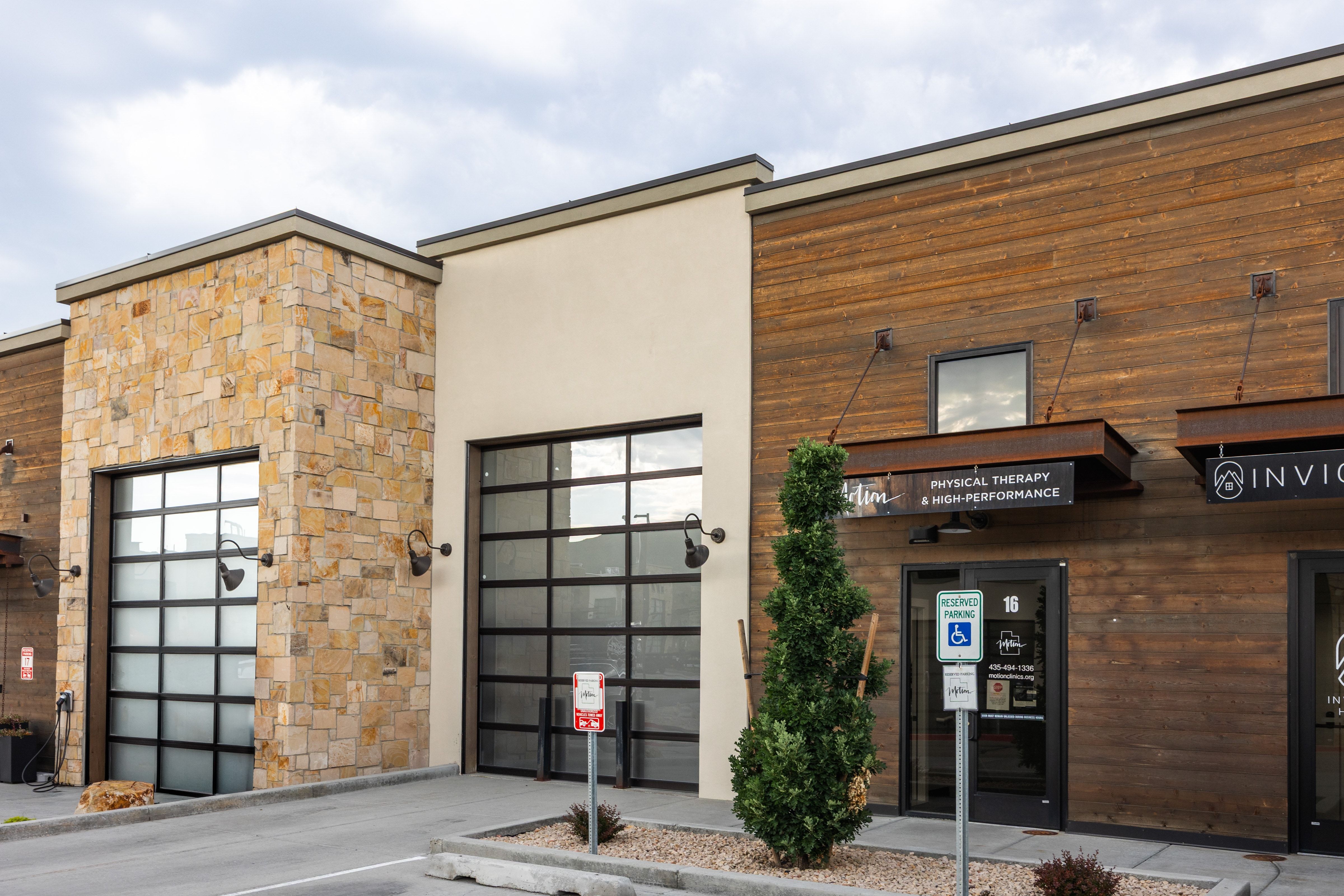 Commercial building exterior featuring stone facade, wood paneling, and stucco finishes