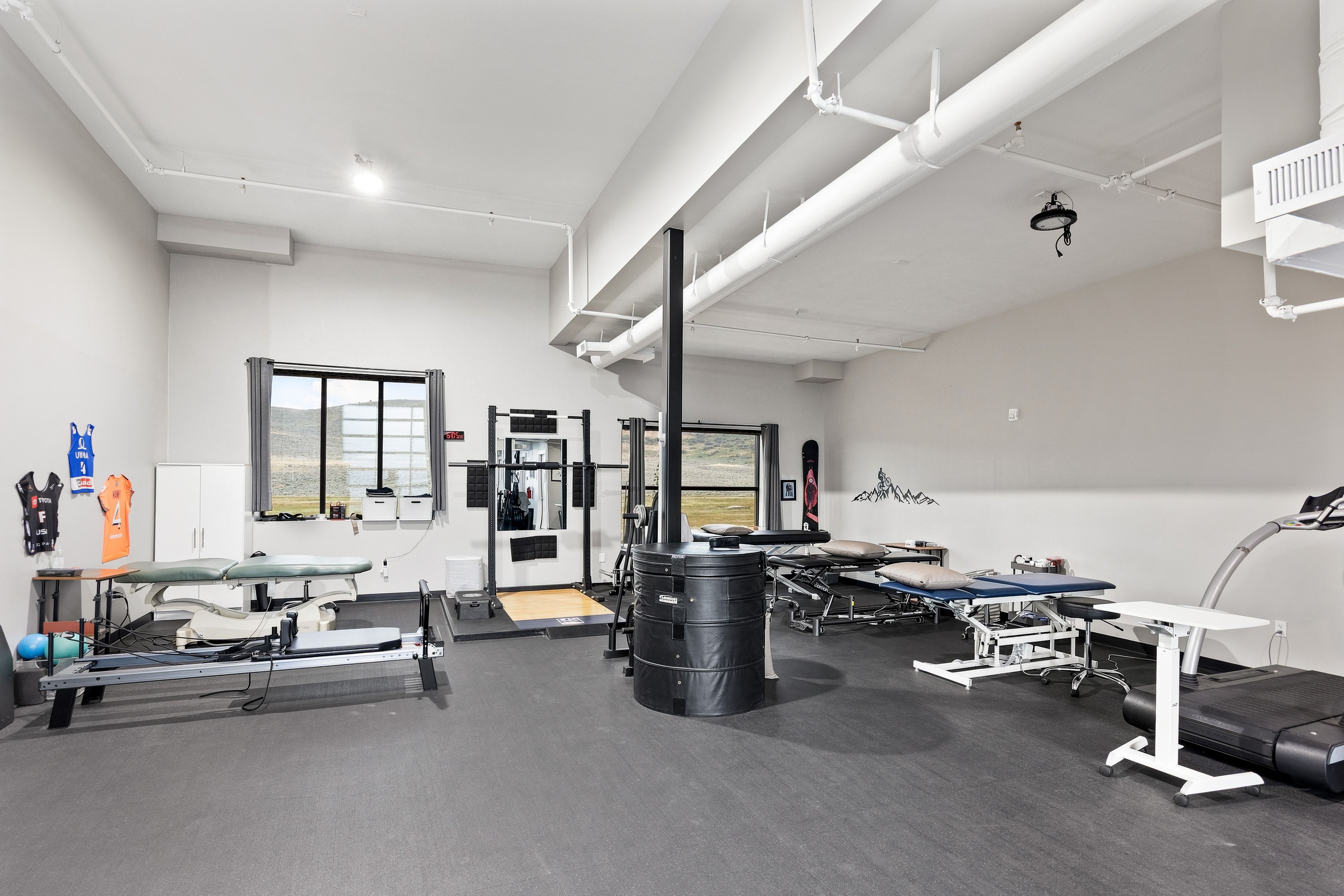 Spacious multi-purpose room featuring neutral walls and dark resilient flooring