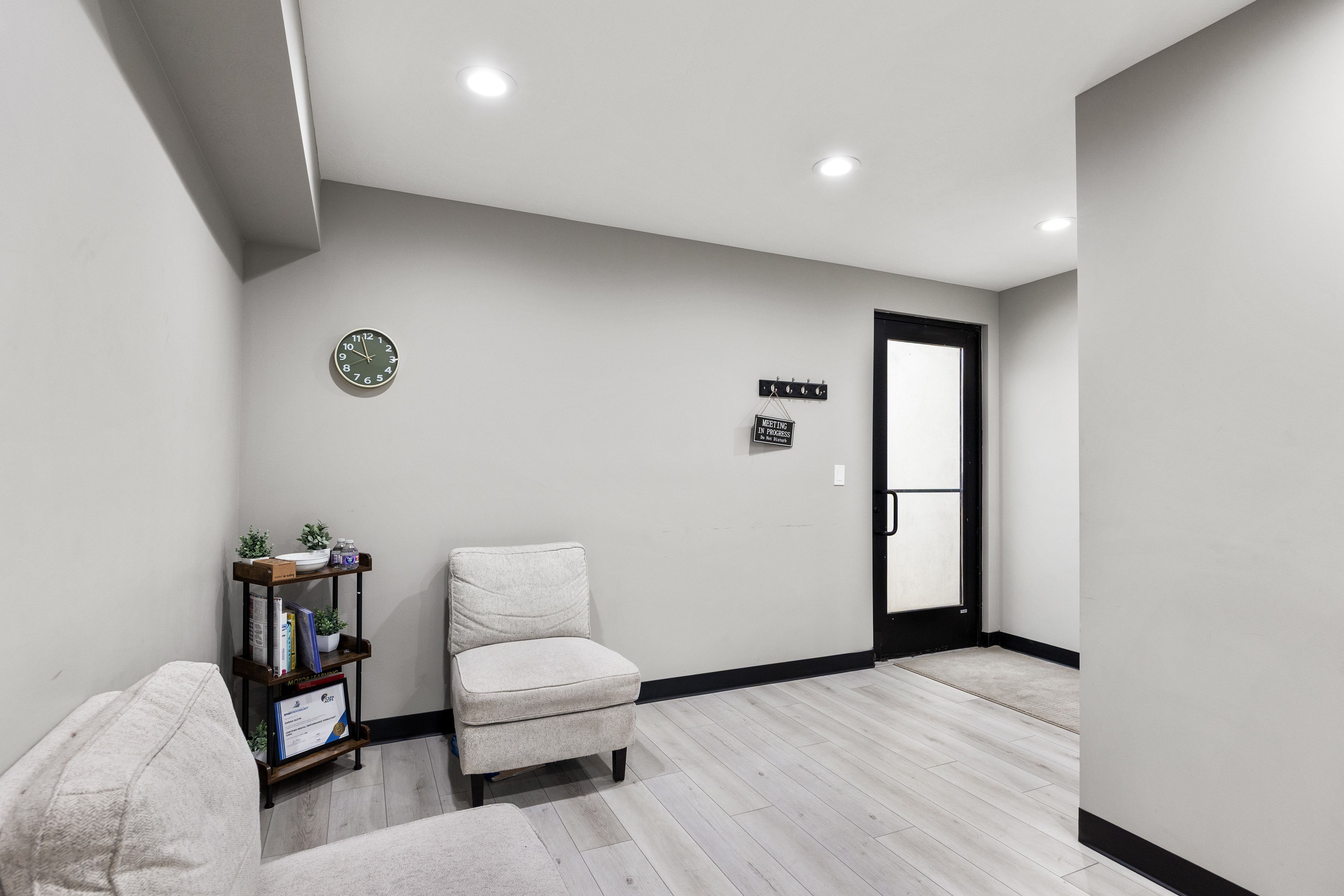 Entryway featuring a black-framed glass panel door, light wood-finish flooring, recessed lighting, and dark baseboards