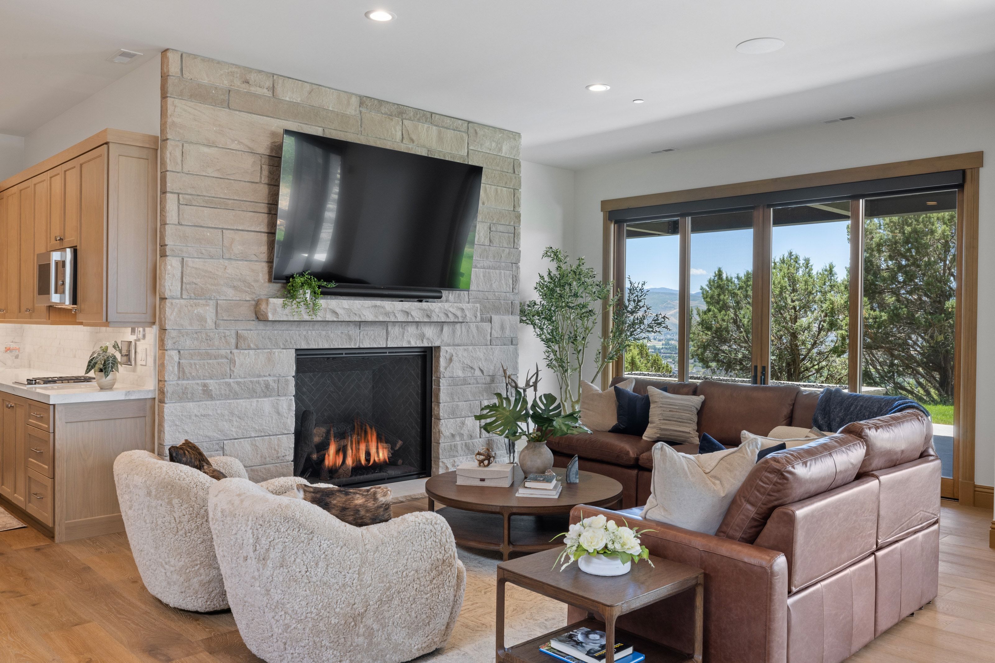 Stone-surround fireplace with a hearth, recessed lighting, and wood-finish flooring
