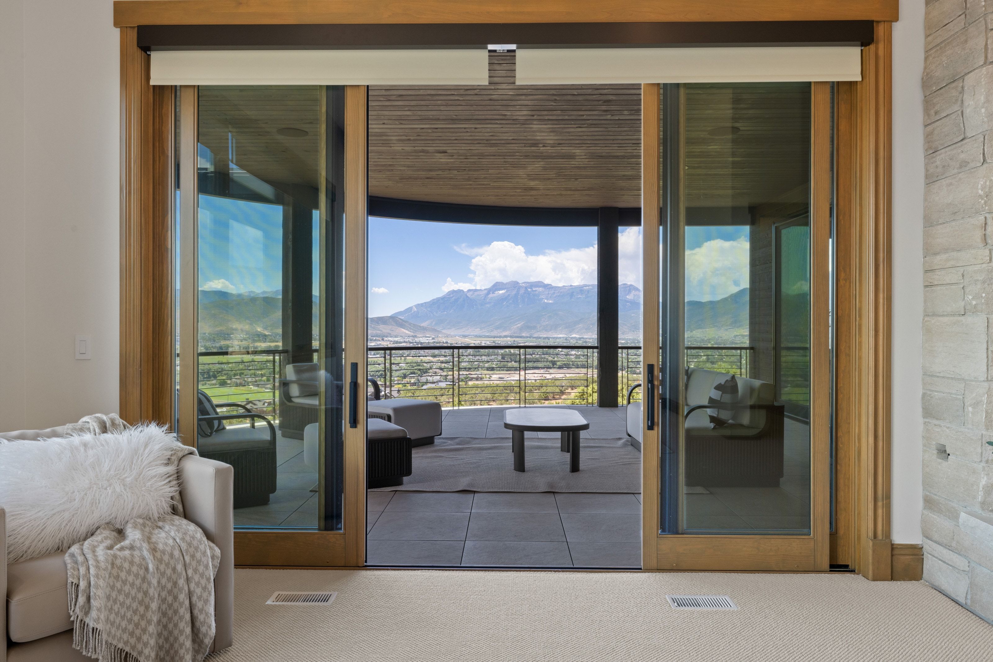 Expansive outdoor patio featuring a neutral-toned tile surface and a metal railing