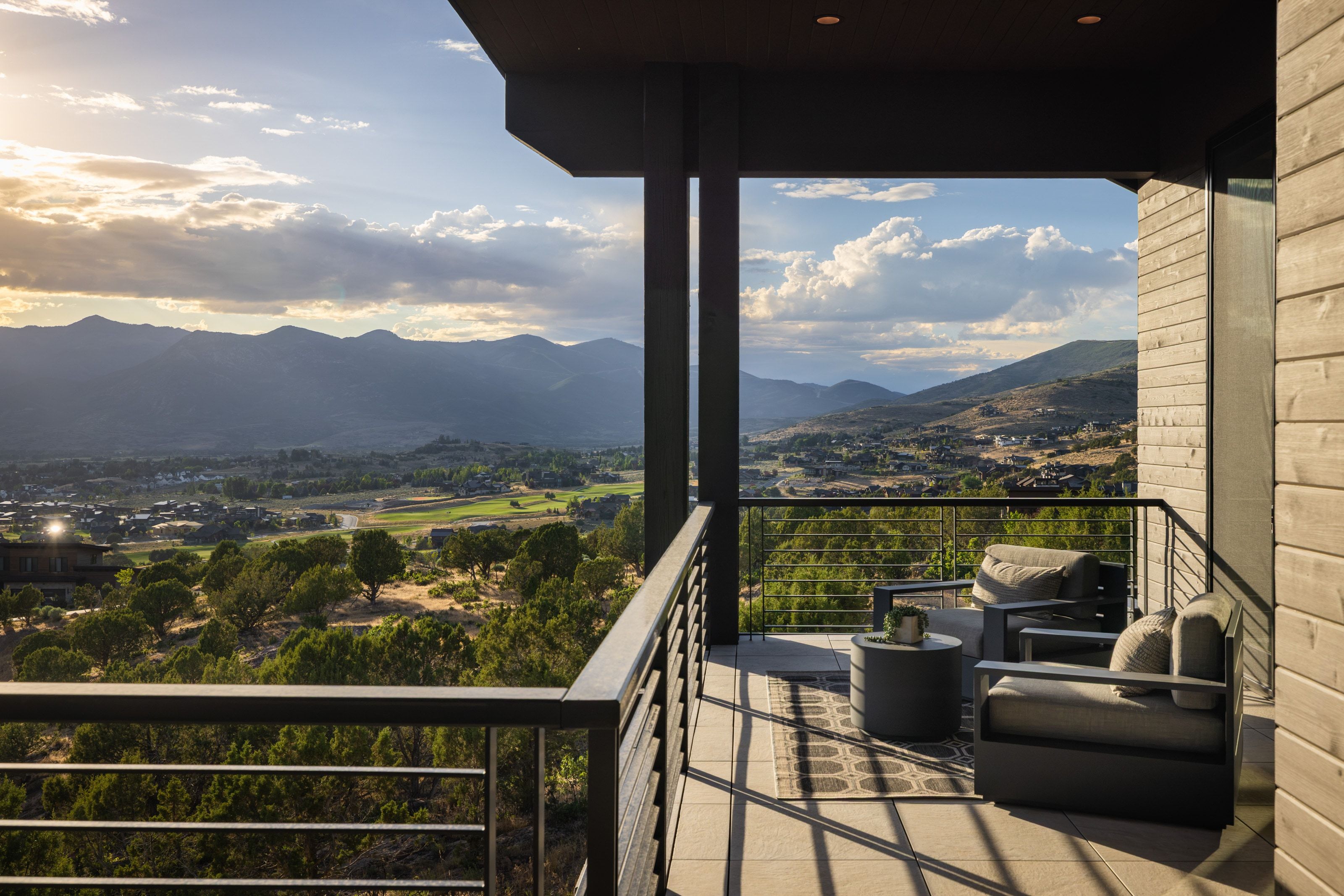 Spacious outdoor balcony featuring a tile floor, metal railing, and wood-finish siding