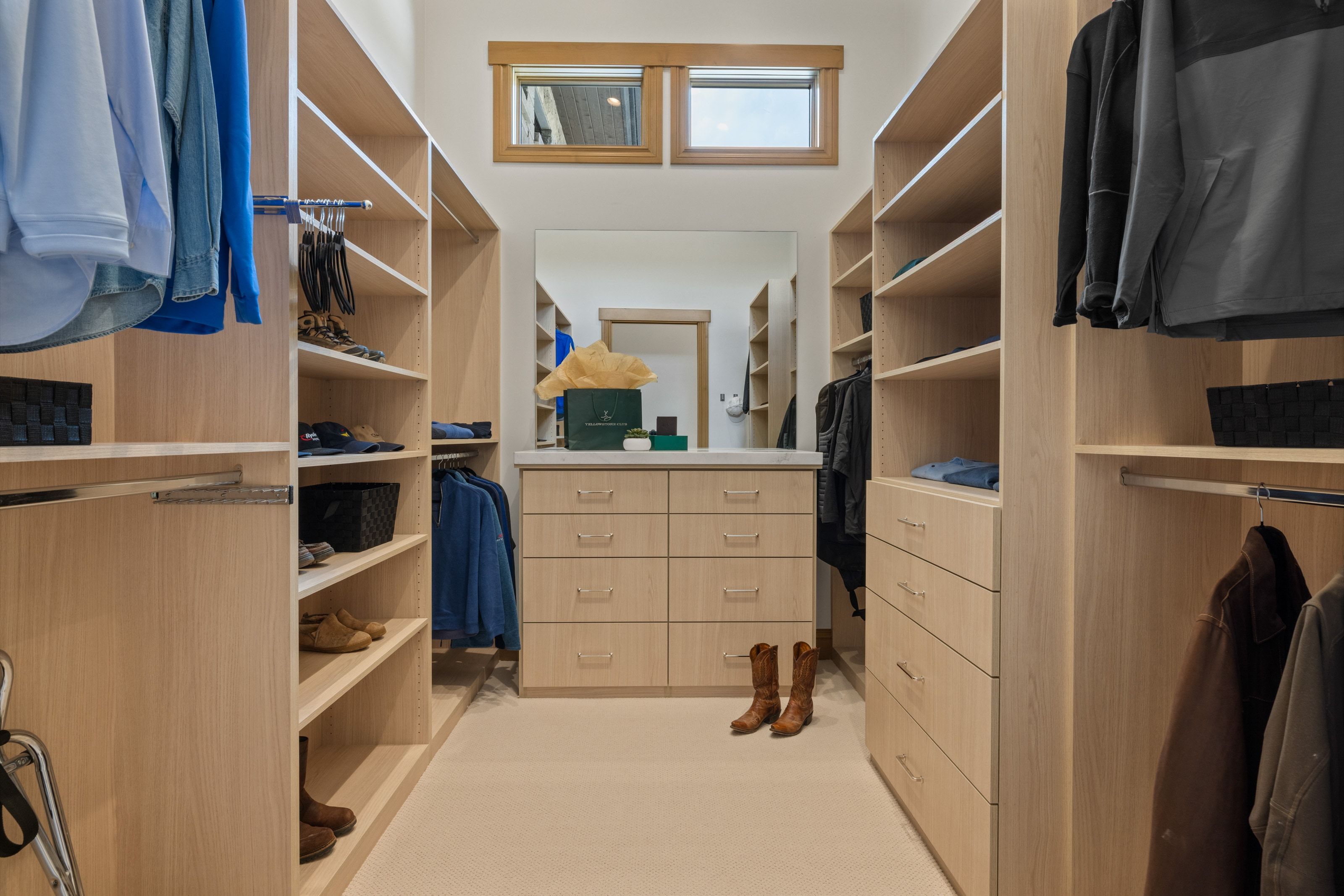 Spacious walk-in closet featuring extensive built-in shelving and hanging rods