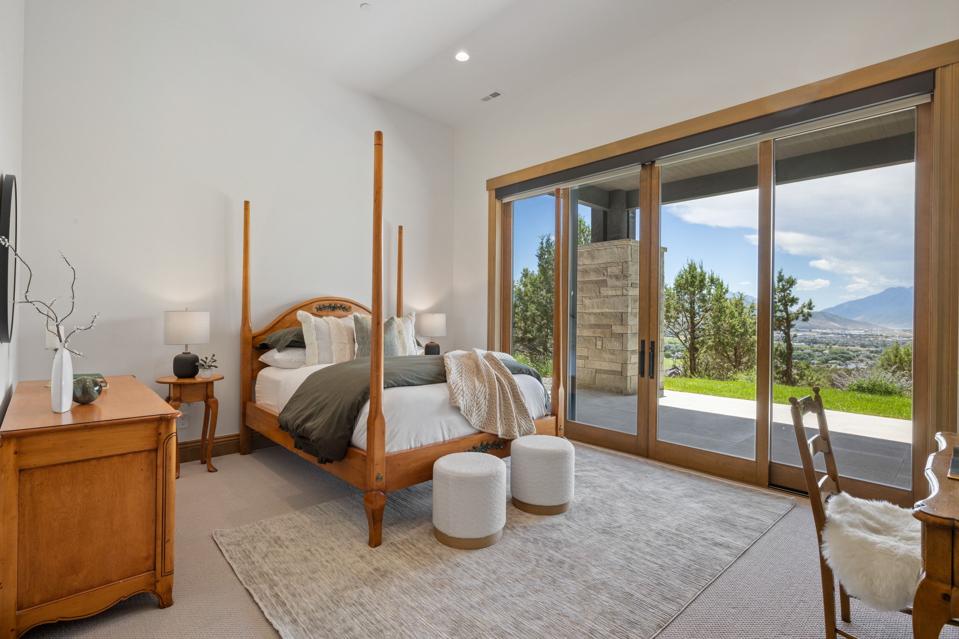 Vaulted ceiling bedroom with large sliding glass doors opening to an outdoor patio