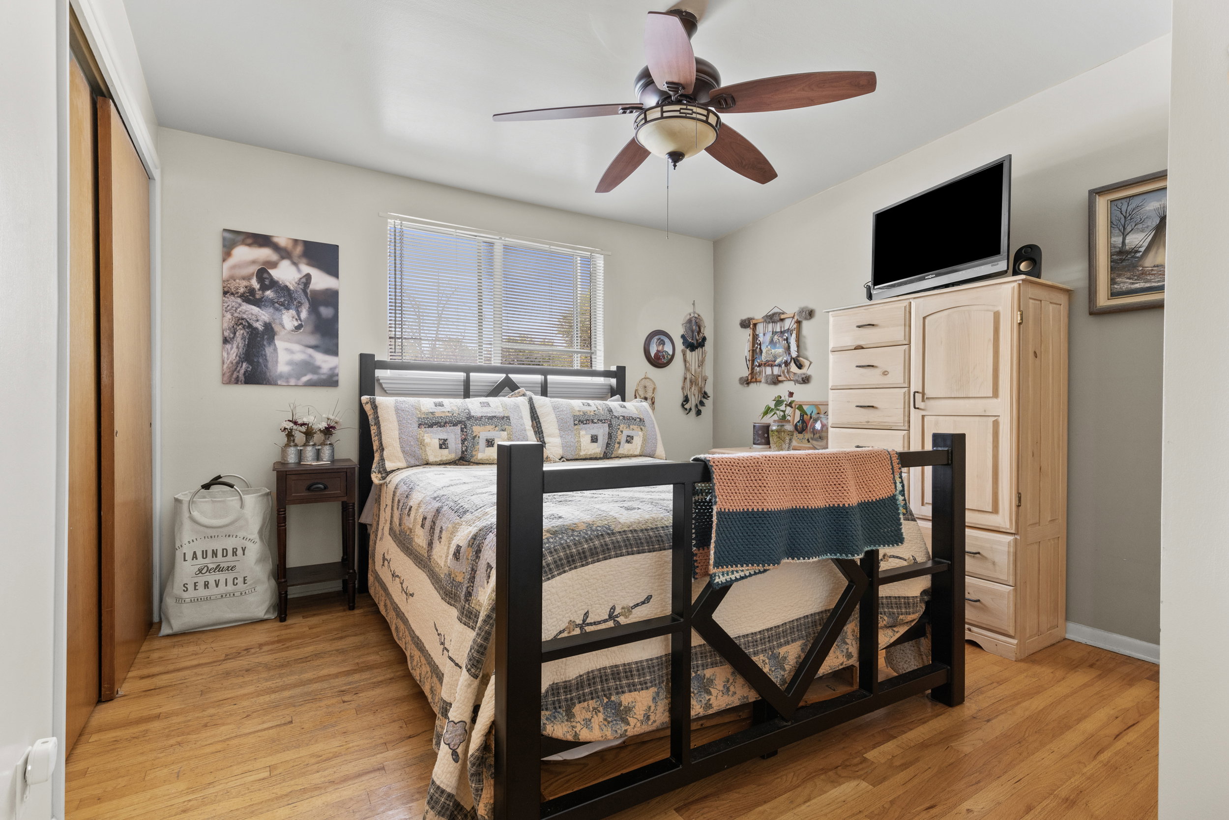 Bright room featuring wood-finish flooring, a ceiling fan with integrated lighting, and a window with natural light