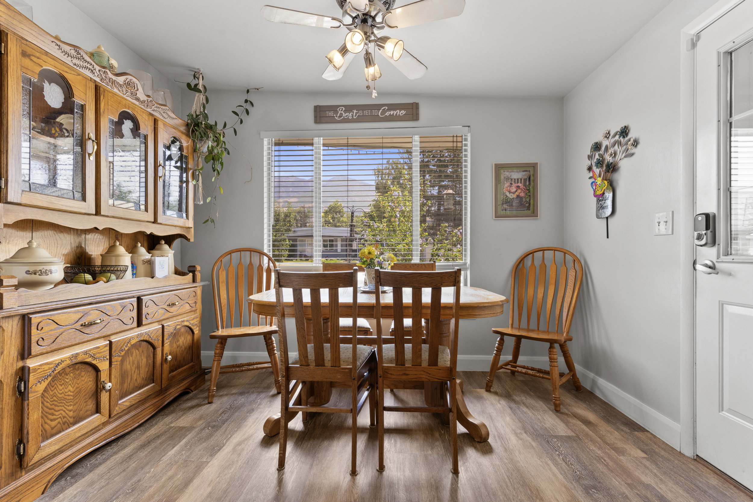 Dining area featuring wood-finish flooring, a window with blinds, and a ceiling fan with integrated lighting