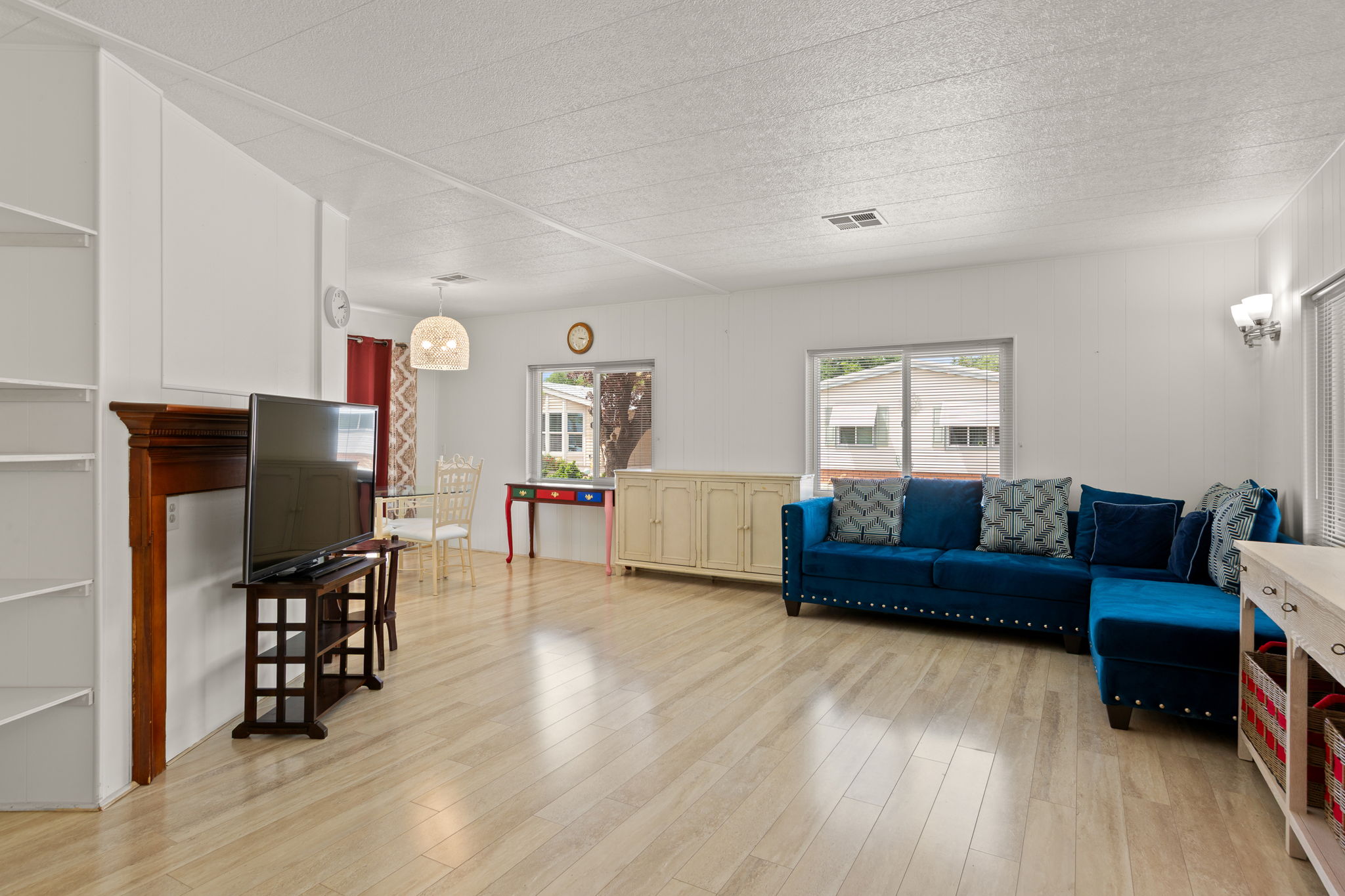 Open living area featuring wood-finish flooring, white walls, and built-in shelving