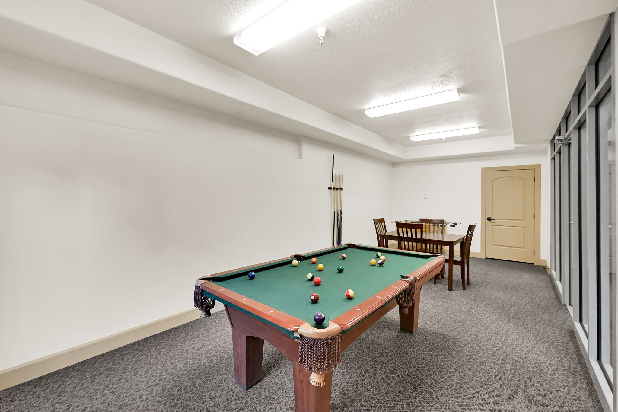 Pool Table on Level G: 10 Level (Ground) Recreation room featuring a billiards table, patterned carpet flooring, a game table with chairs, and a foosball table