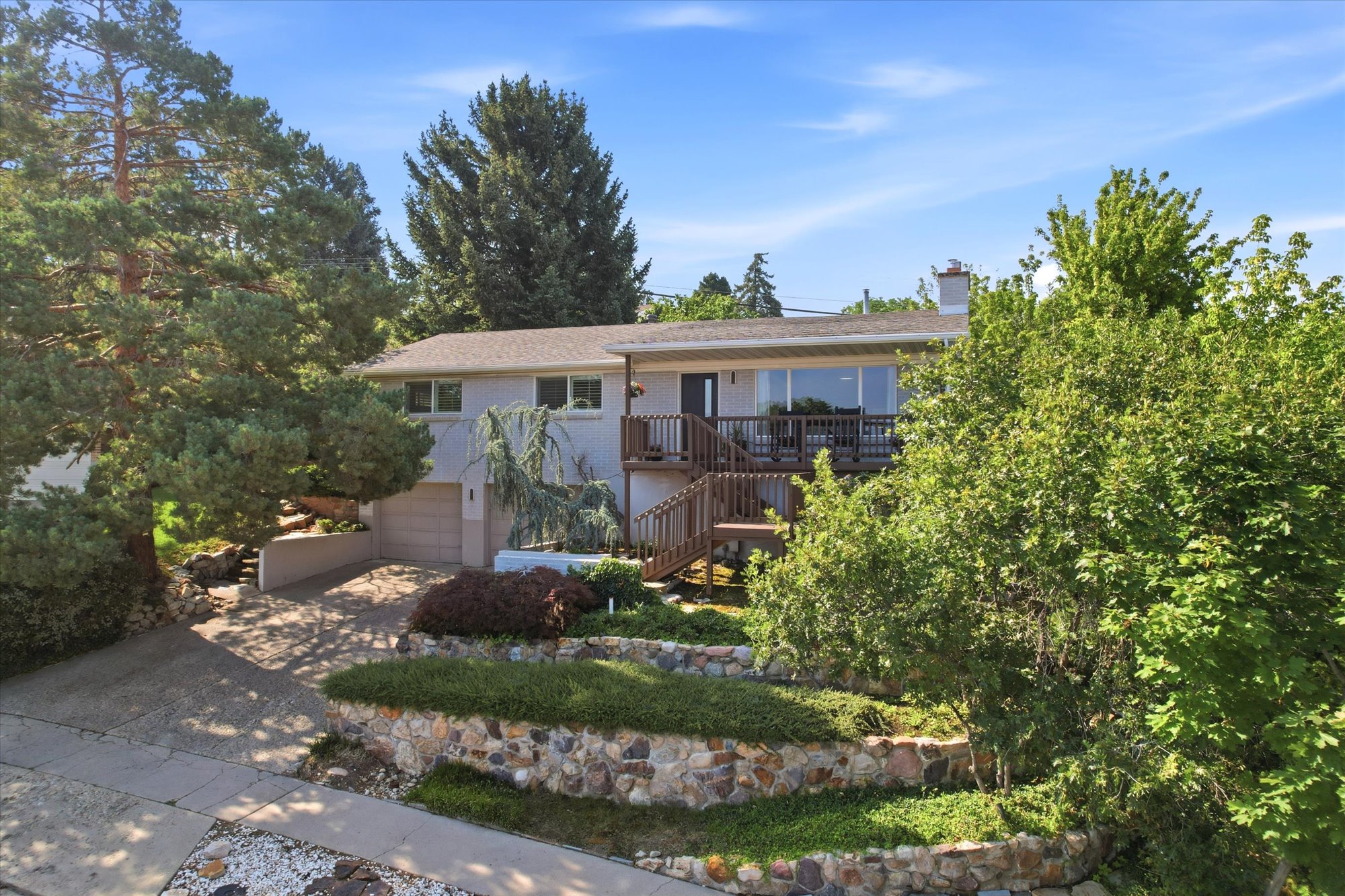 Split-level residence featuring a two-car garage and a wood deck