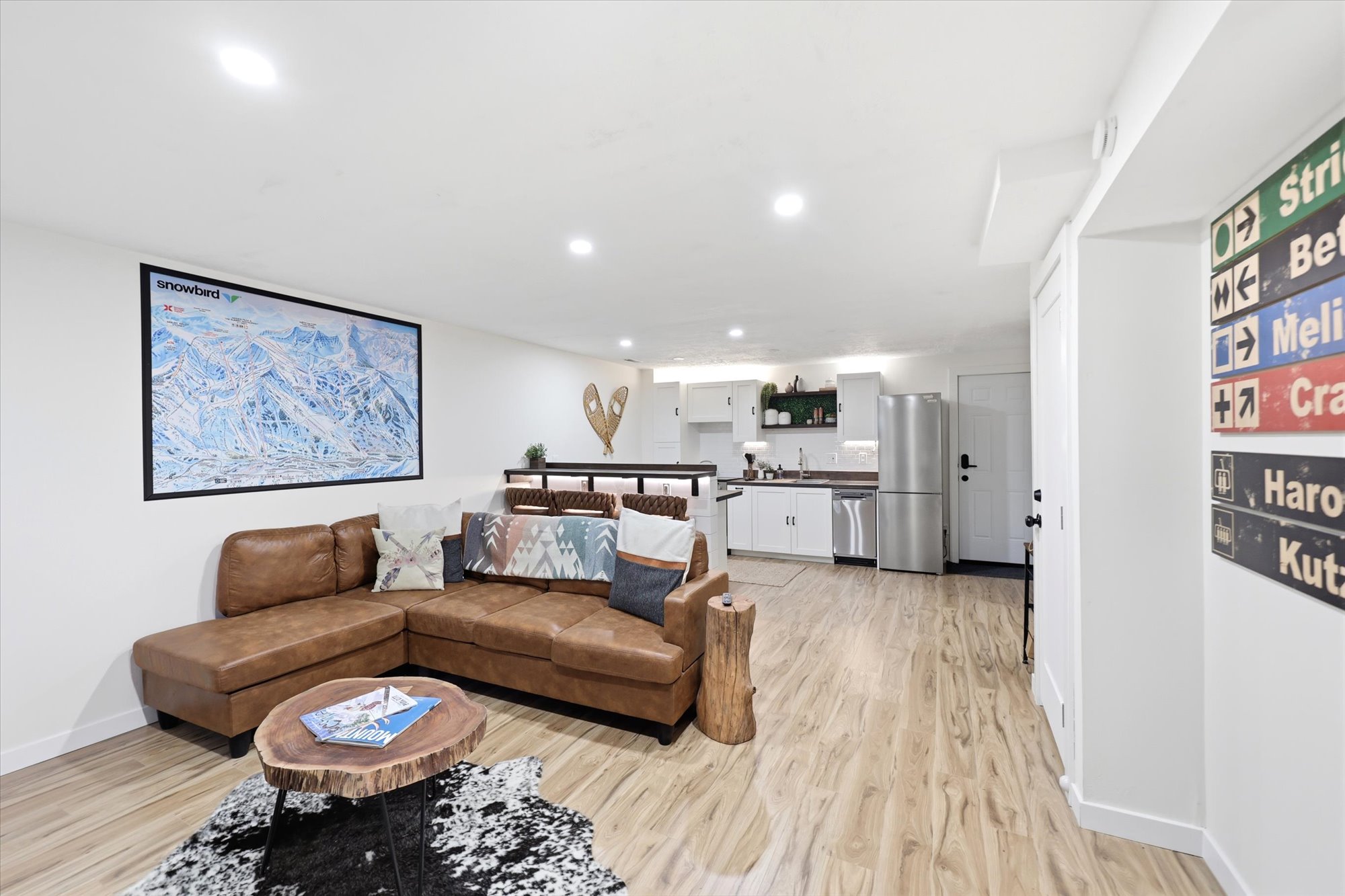 Open concept living area featuring wood-finish flooring, recessed lighting, and a kitchen area with stainless steel appliances