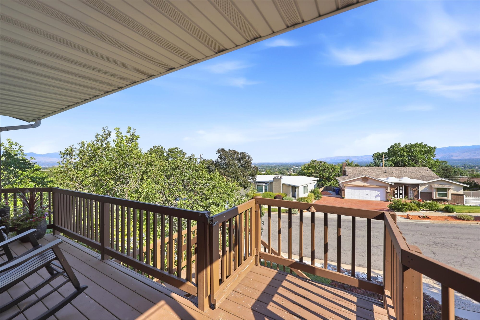 Expansive outdoor deck featuring wood-finish railing, composite decking, and an overhead awning