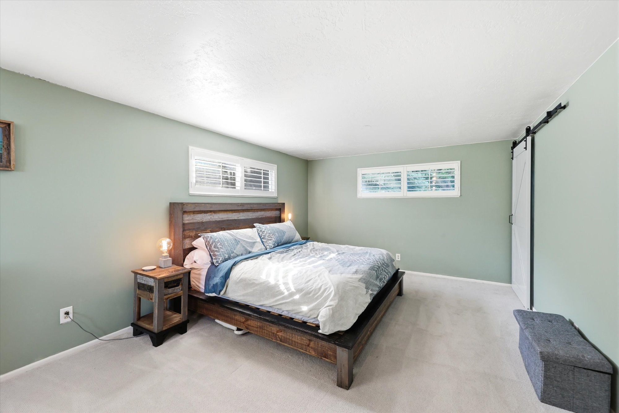 Spacious room with light green walls and plush carpeting